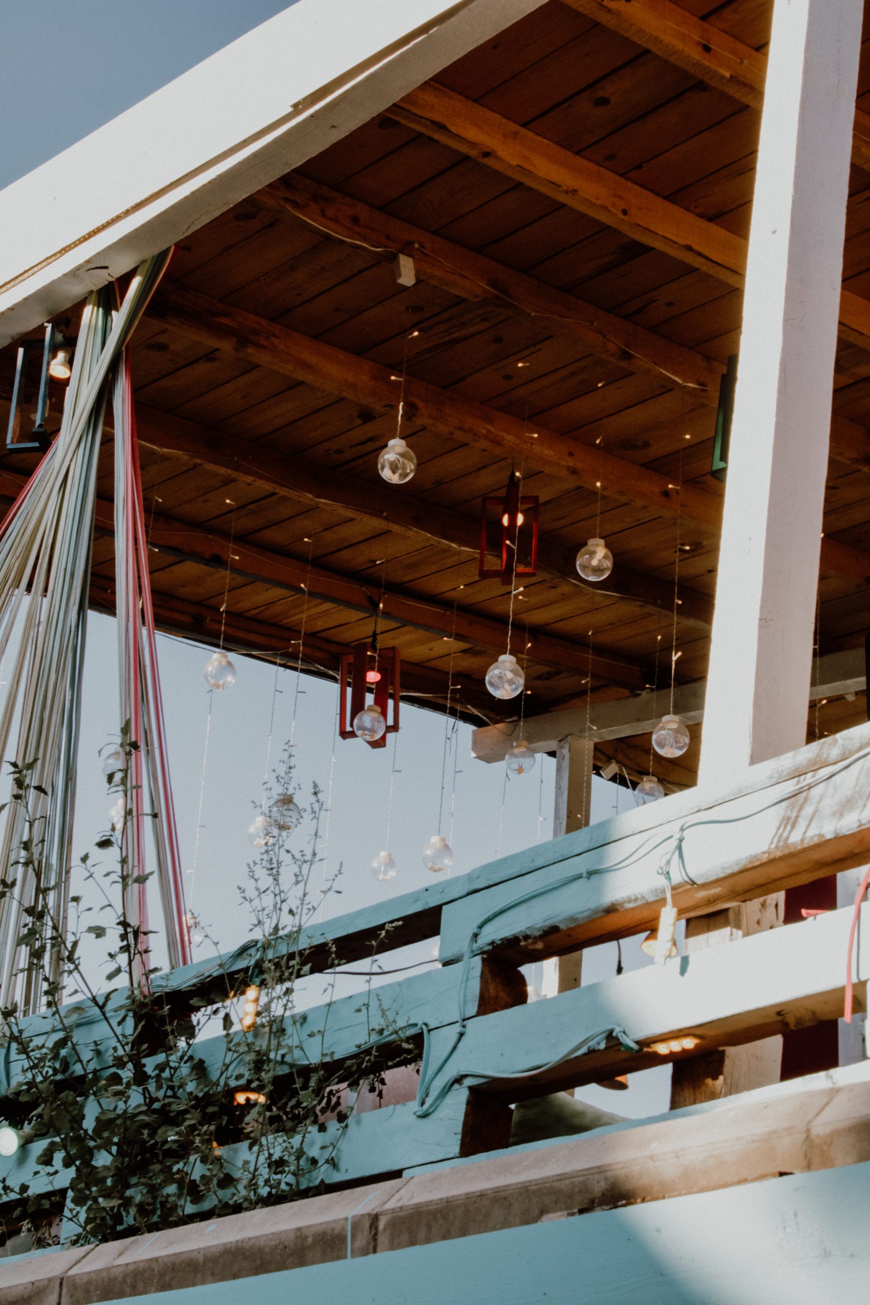 Charming outdoor patio featuring hanging lights and a wooden roof, creating a cozy ambiance.