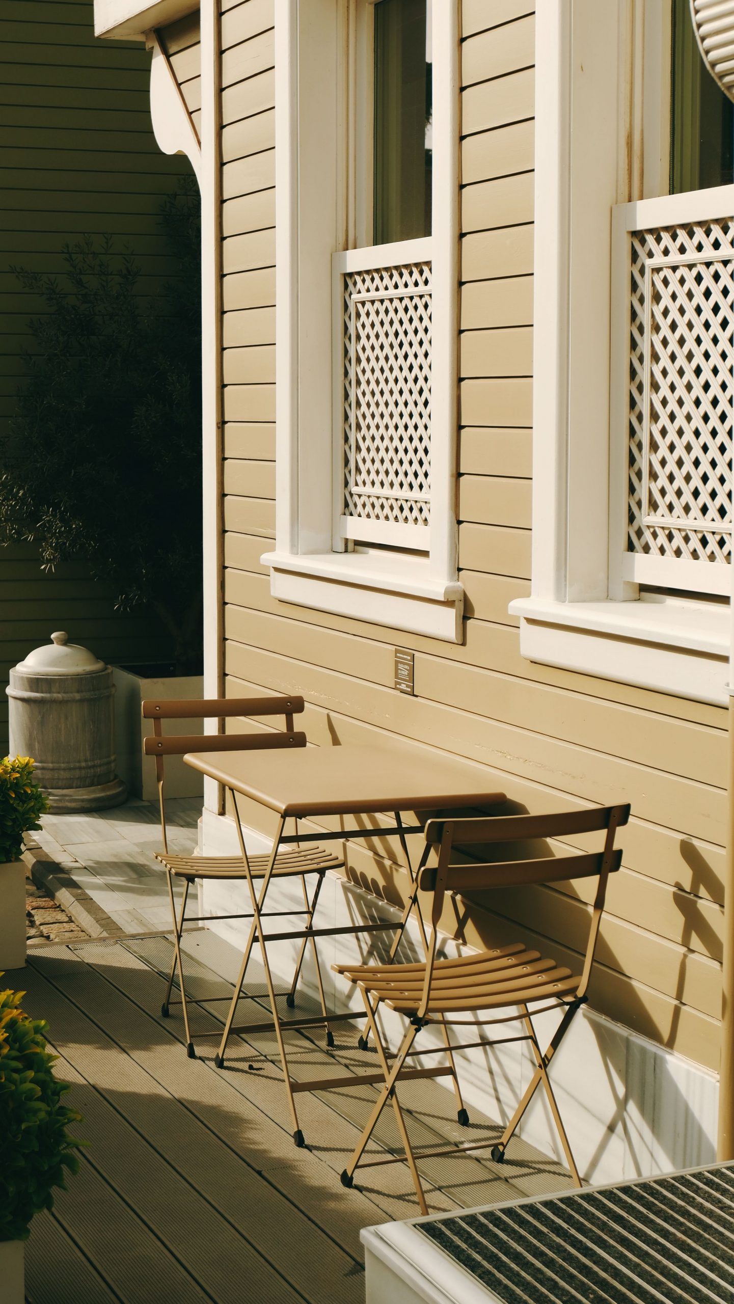 Charming porch scene with wooden table and chairs, perfect for relaxation.