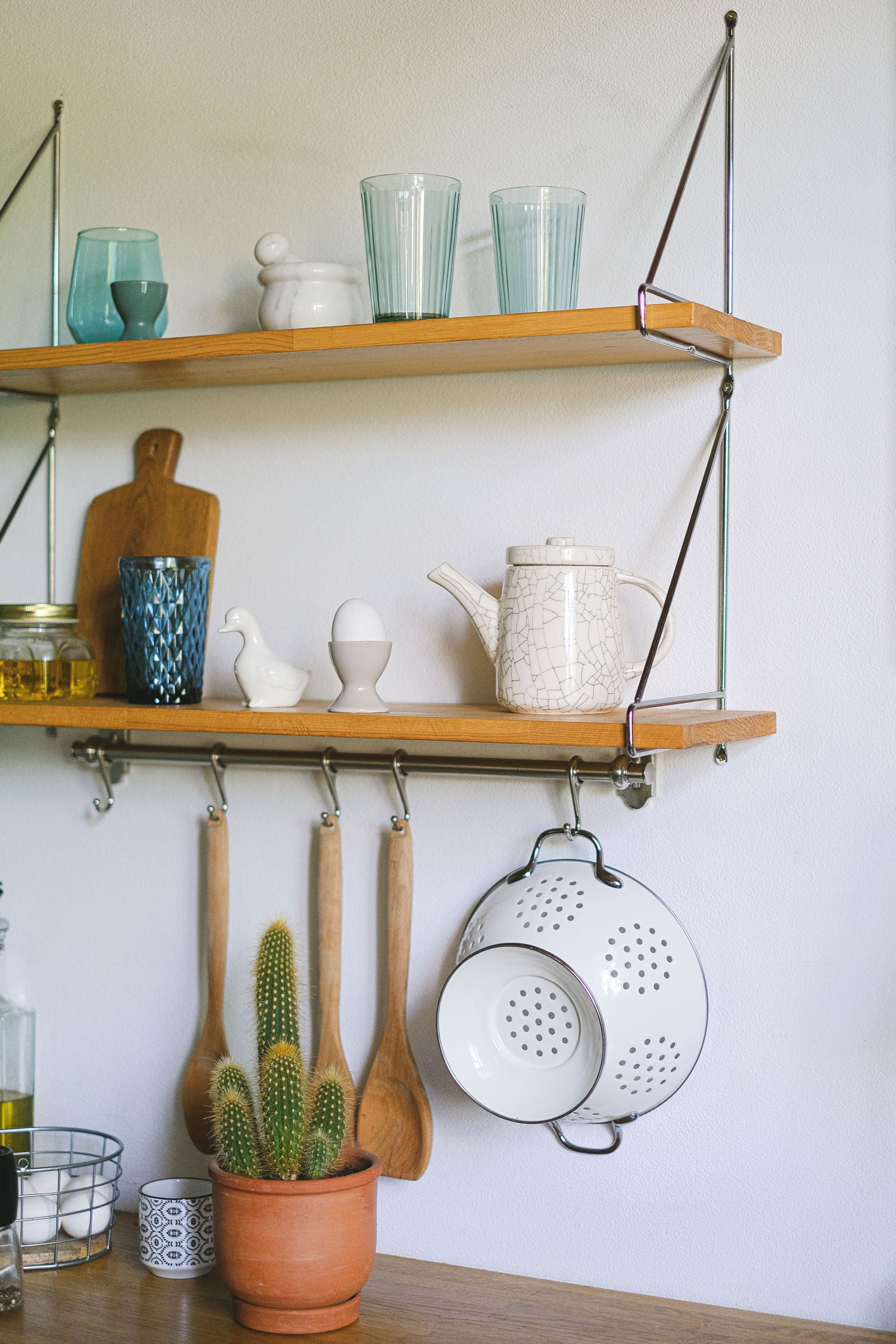 Charming rustic kitchen setup with wooden shelves, utensils, and decor elements.