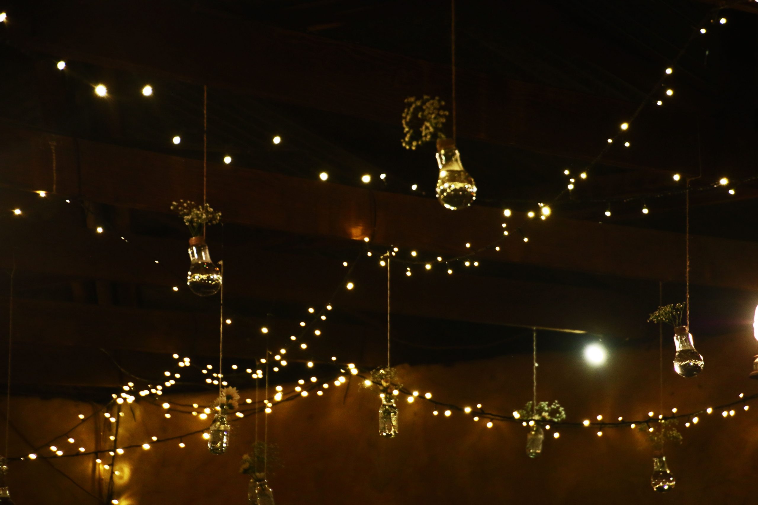 Cozy indoor scene with string lights and hanging jar decor creating a warm ambiance.