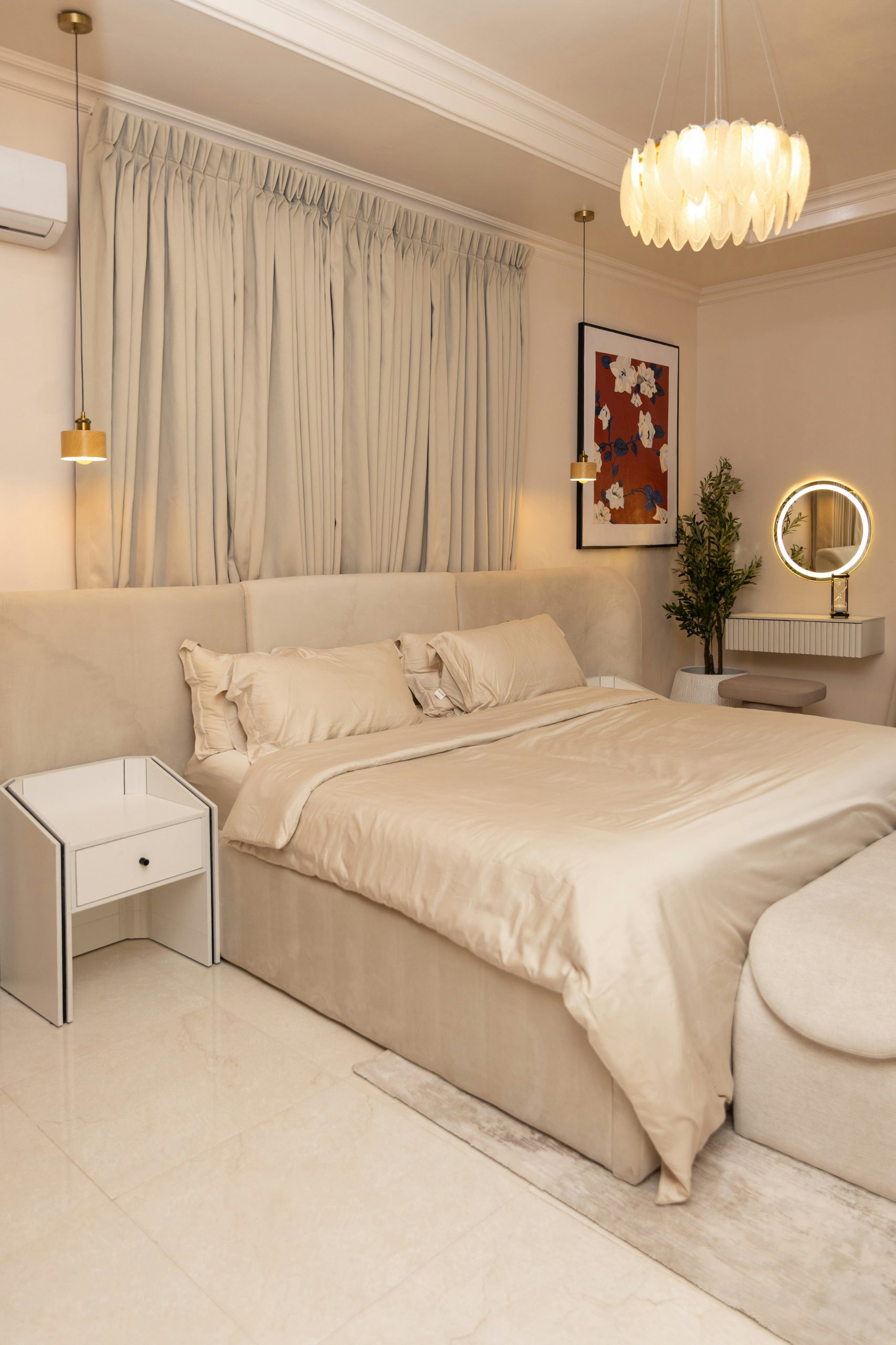 Elegant bedroom with a large bed, nightstand, and vanity.