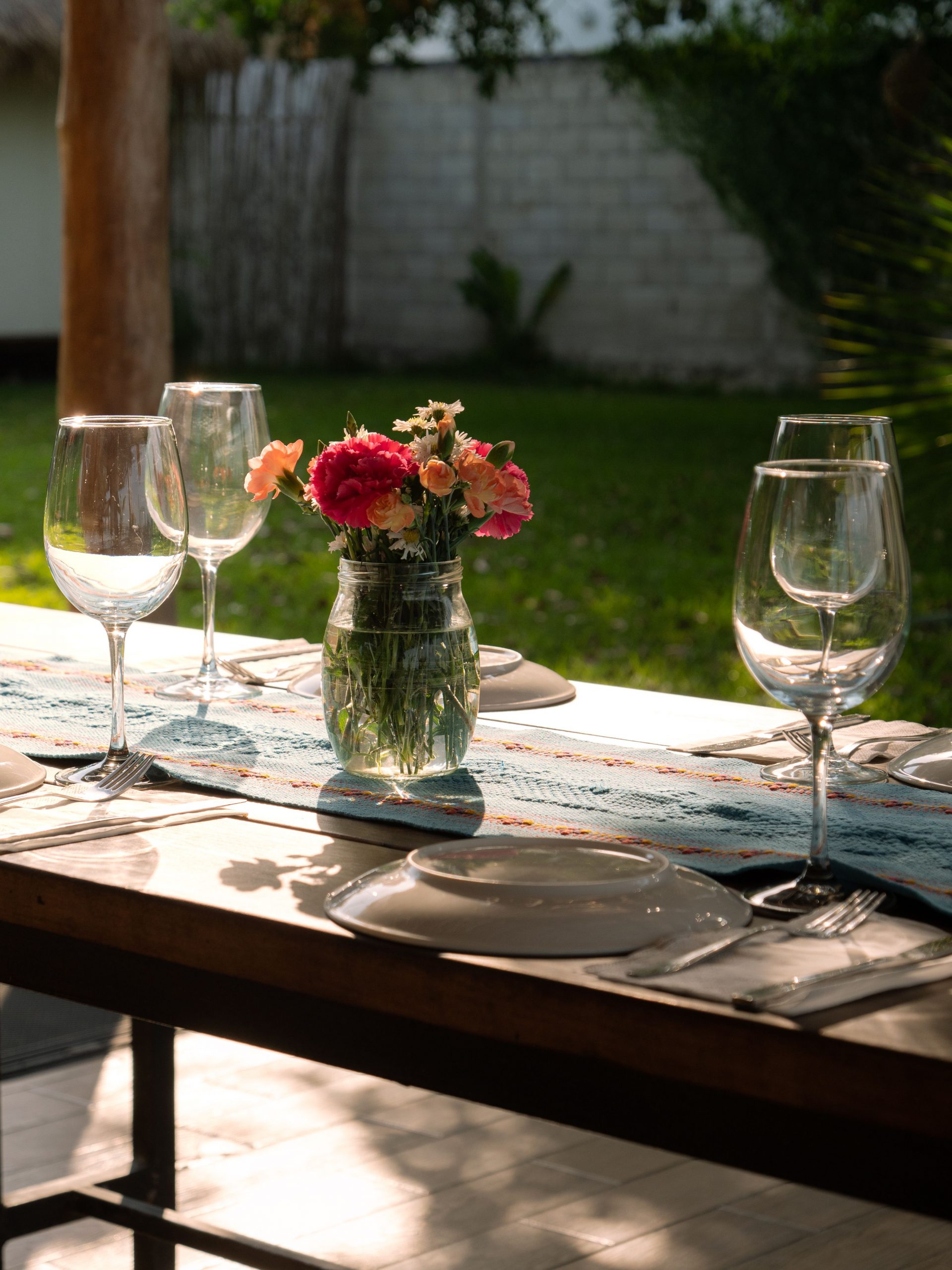 Elegant outdoor dining setup with flowers and wine glasses in Bacalar, Mexico.
