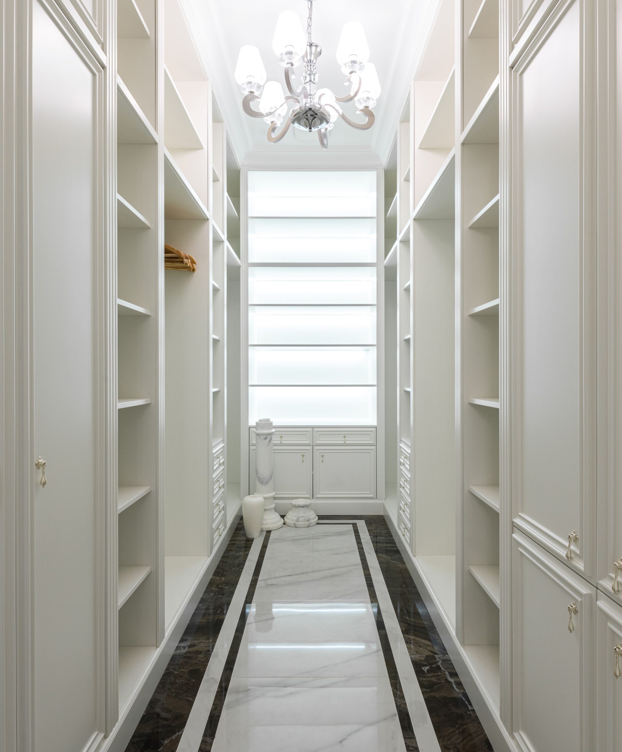 Interior of contemporary luxury apartment with large wardrobe with shelves under glowing lamps