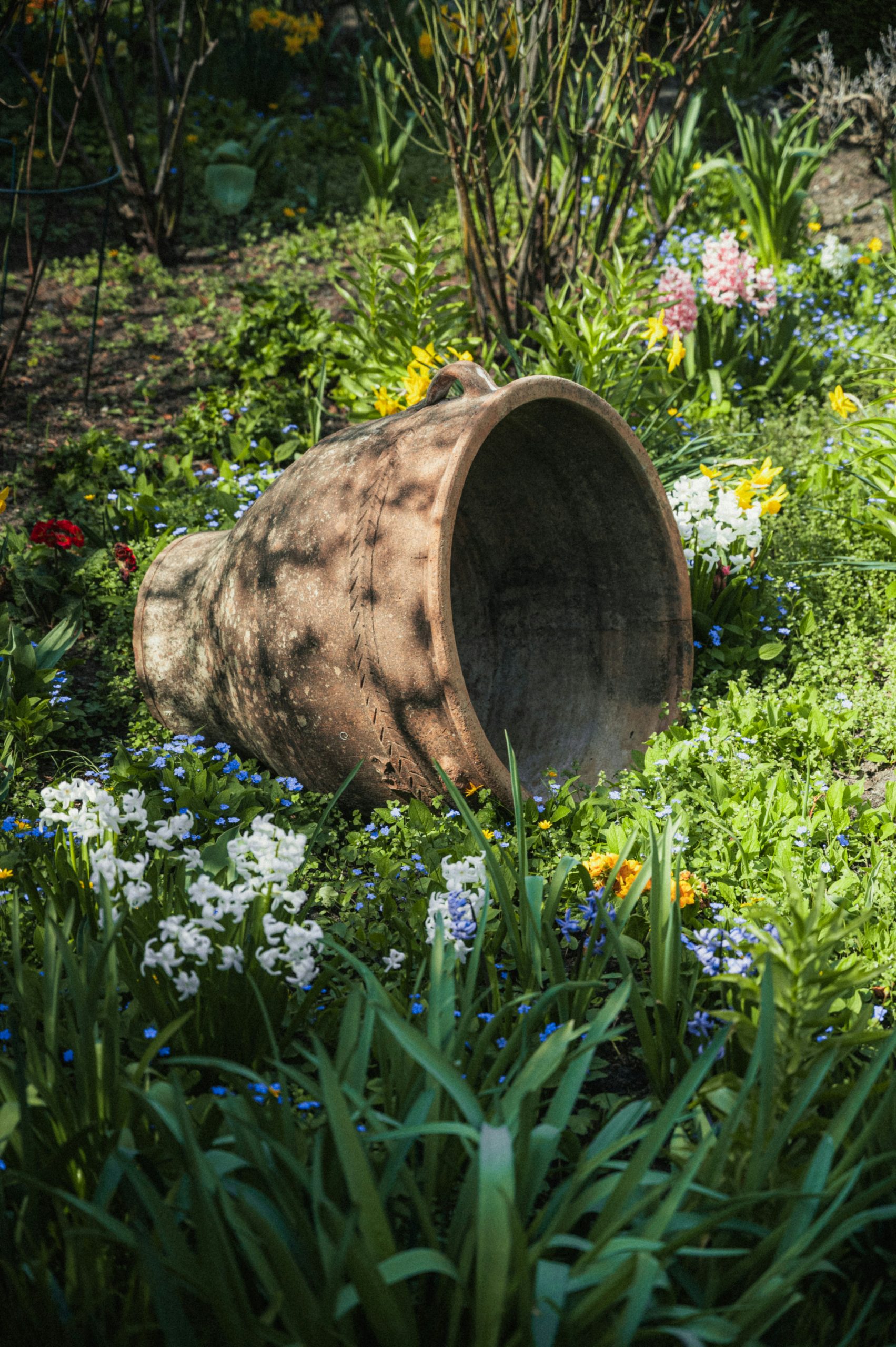 Overturned pot surrounded by wildflowers.