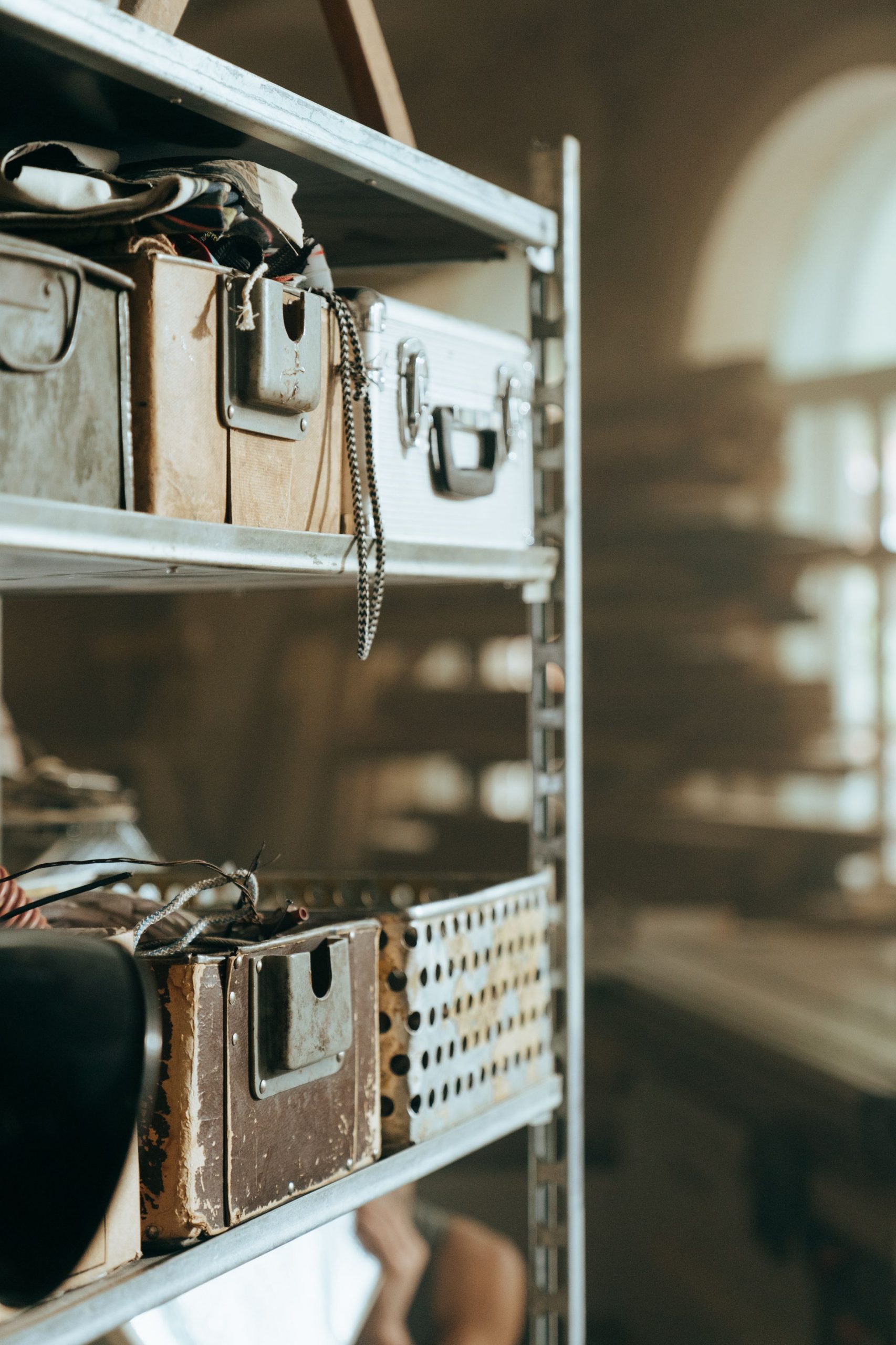 Rustic metal shelving filled with vintage boxes in a craftsman's workshop.