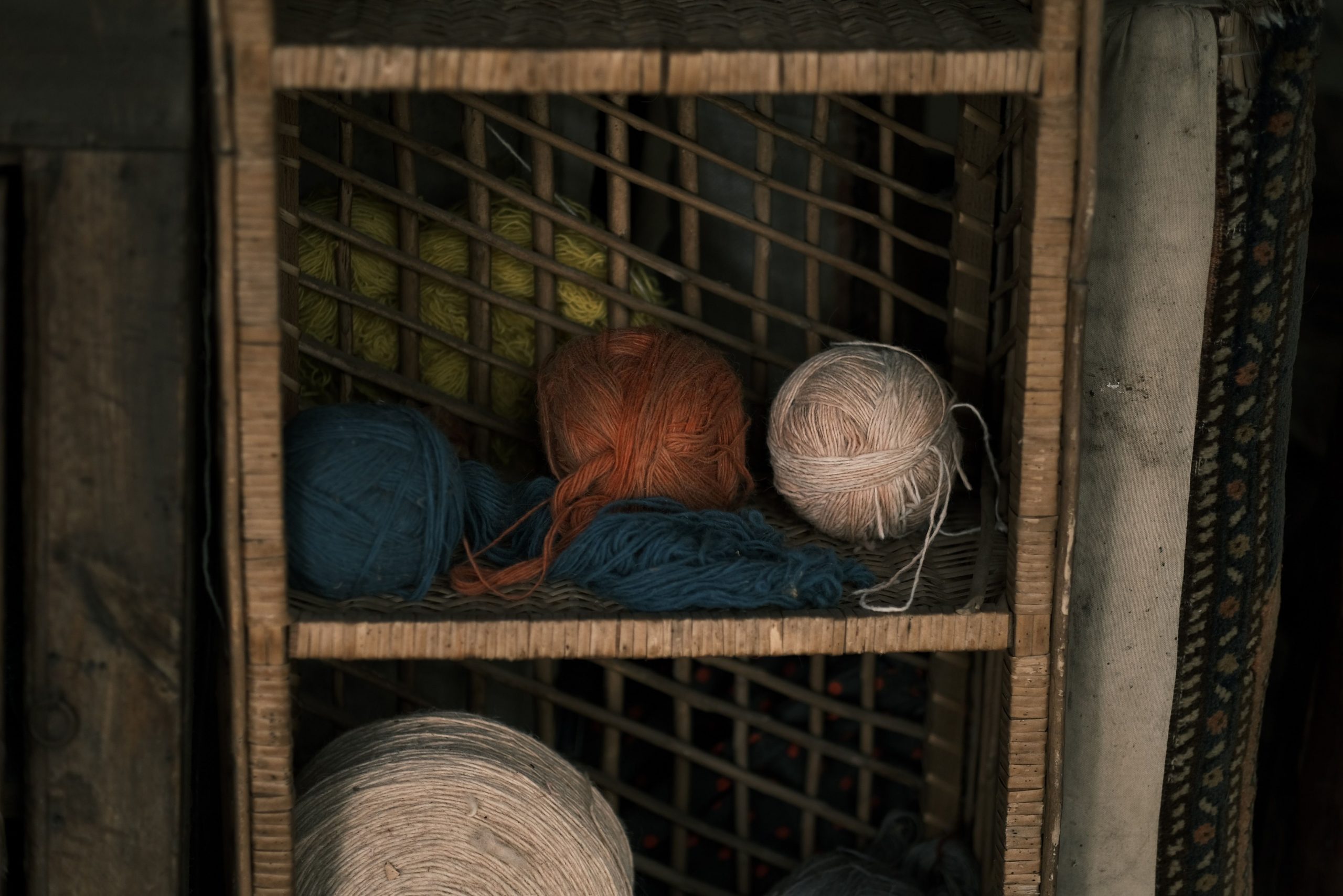 Vibrant yarn balls in rustic wooden shelf setting, capturing the essence of crafting materials.