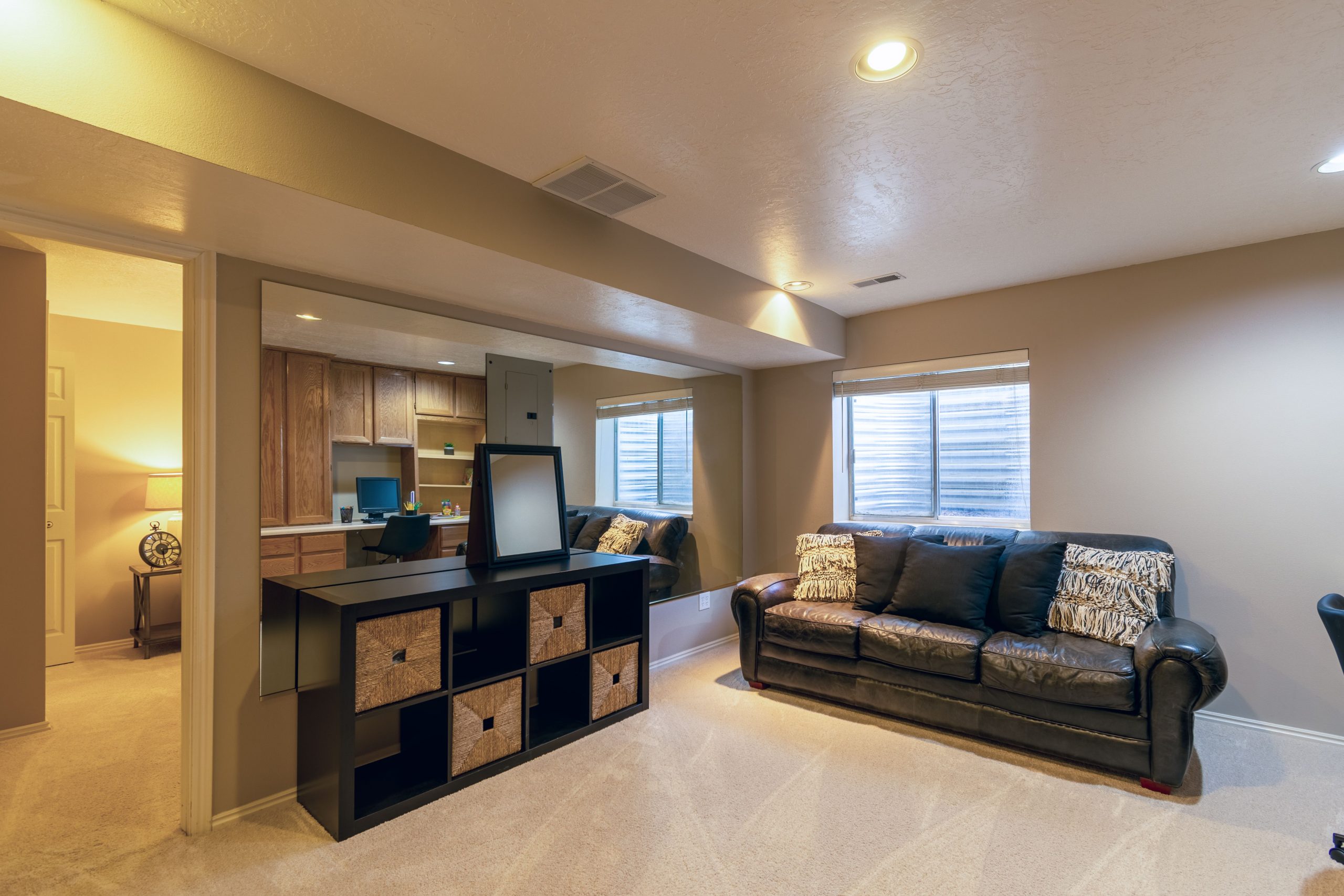 Warm and inviting basement living room featuring a leather sofa and modern decor.