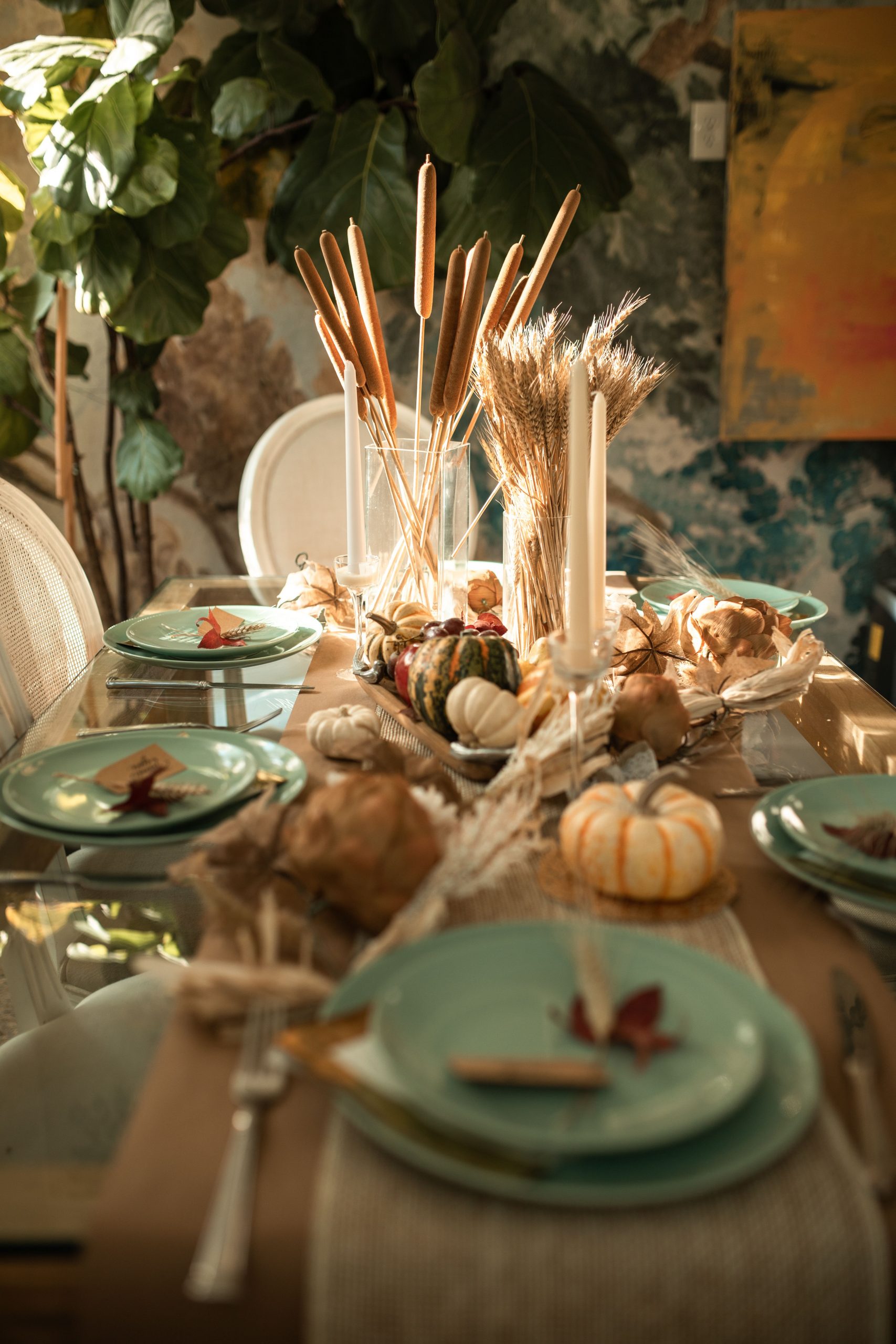 A beautifully arranged autumn table setting with pumpkins and candles for a festive celebration.