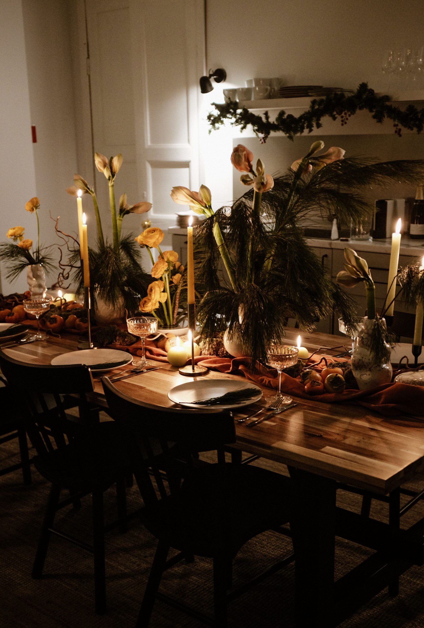 A beautifully arranged dining table with lighted candles and floral decor, perfect for festive dinners.