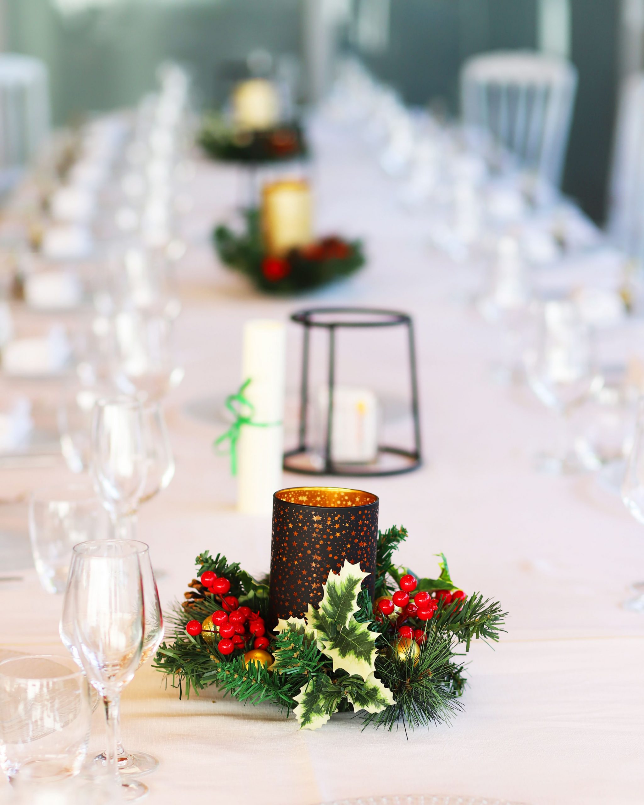 A beautifully arranged table with candles and greenery, perfect for a holiday or festive gathering.