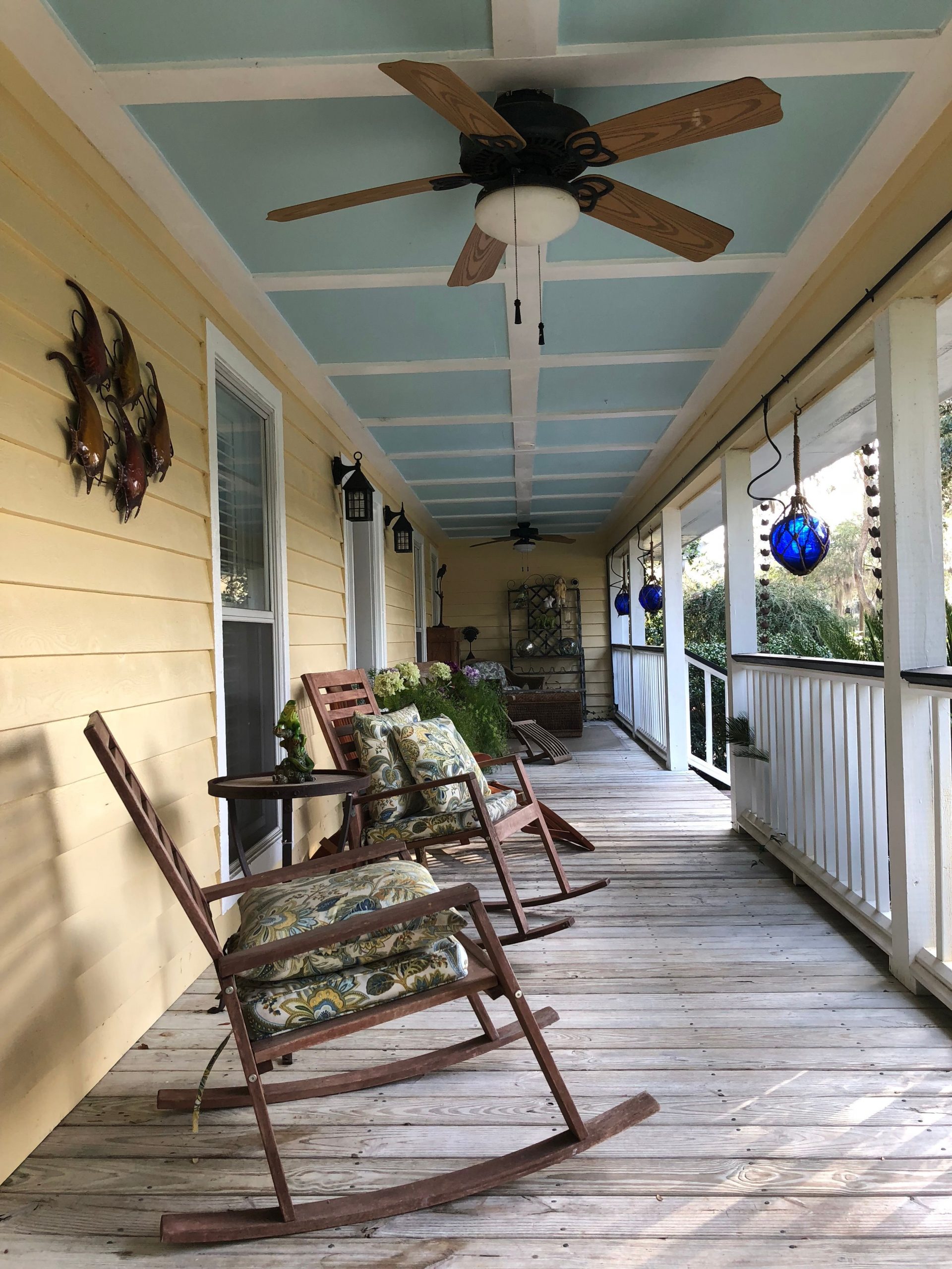 A classic southern porch with wooden rocking chairs and hanging decor creates a cozy atmosphere in Mount Pleasant, SC.