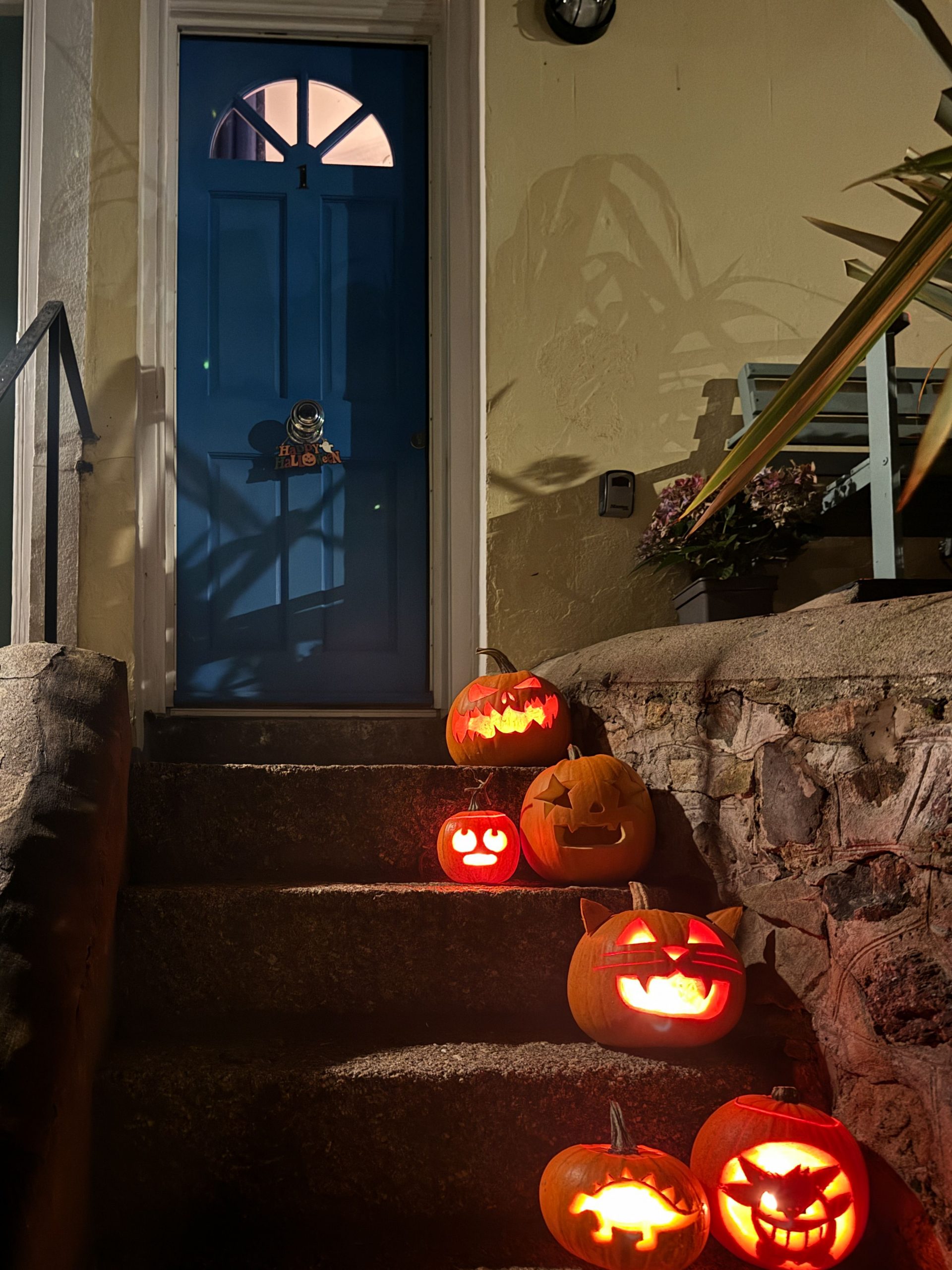 A collection of carved pumpkins on doorstep stairs celebrating Halloween in St Ives, England.