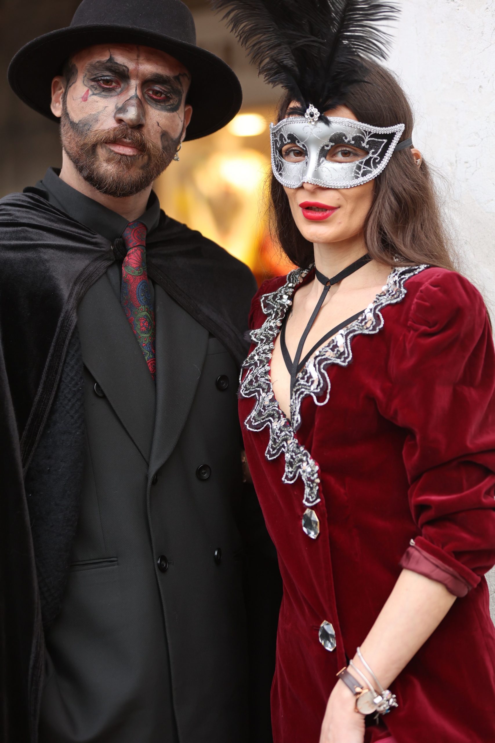 A couple in elegant costumes and masks, embodying the essence of a classic carnival event.
