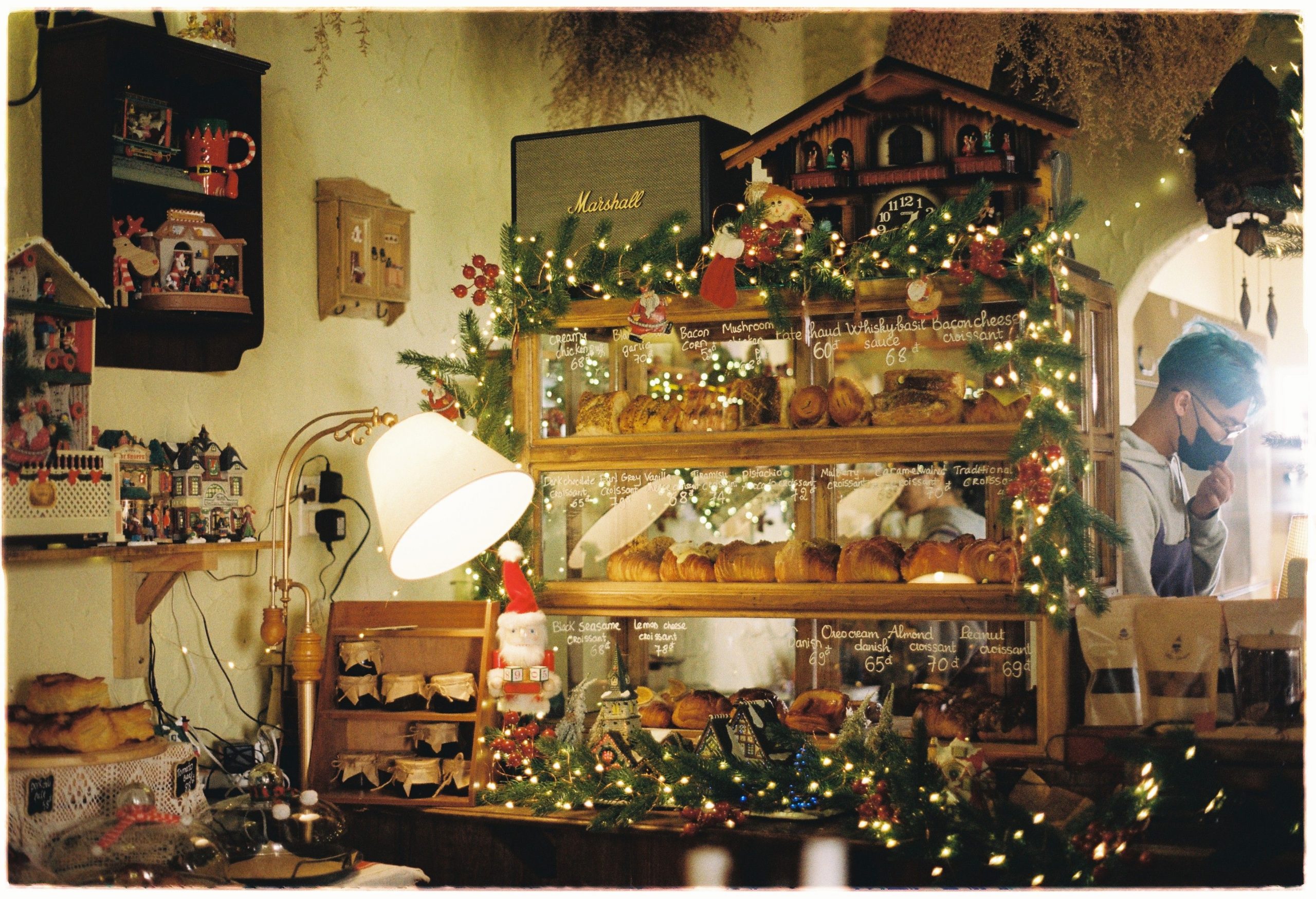 A cozy bakery adorned with holiday lights and baked goods on display.