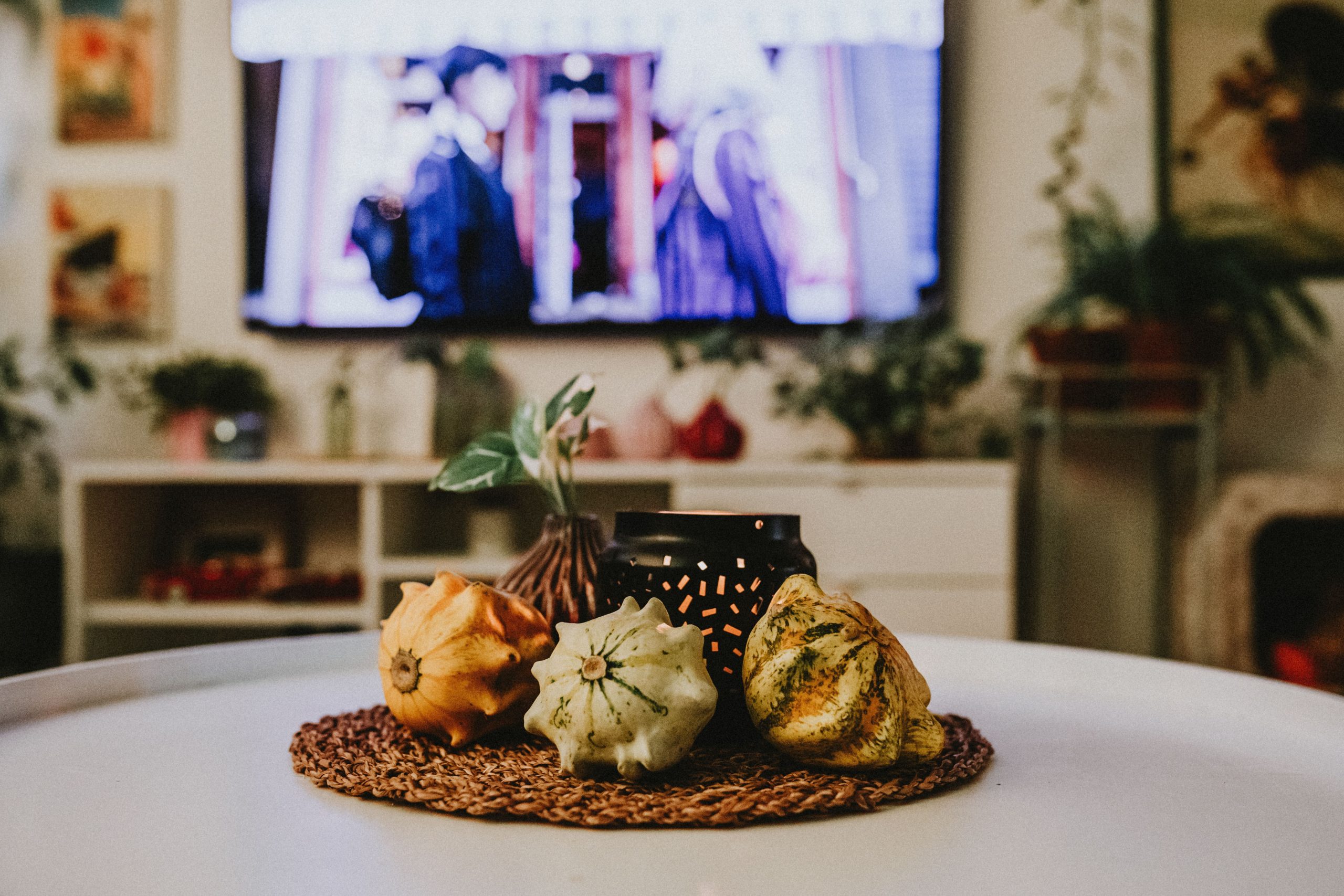 A cozy indoor scene featuring autumn-themed gourds and rustic decor on a table.