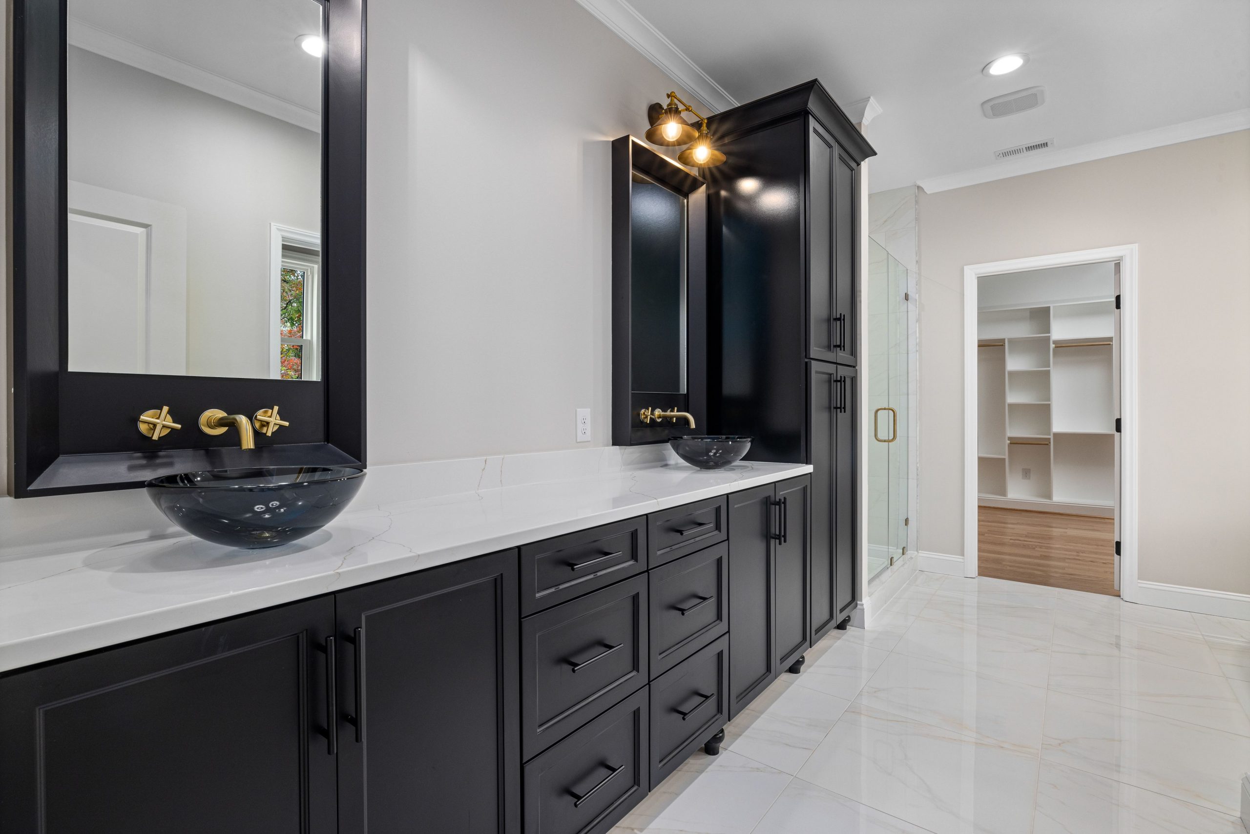 A sleek and contemporary bathroom featuring black cabinets and dual sinks.