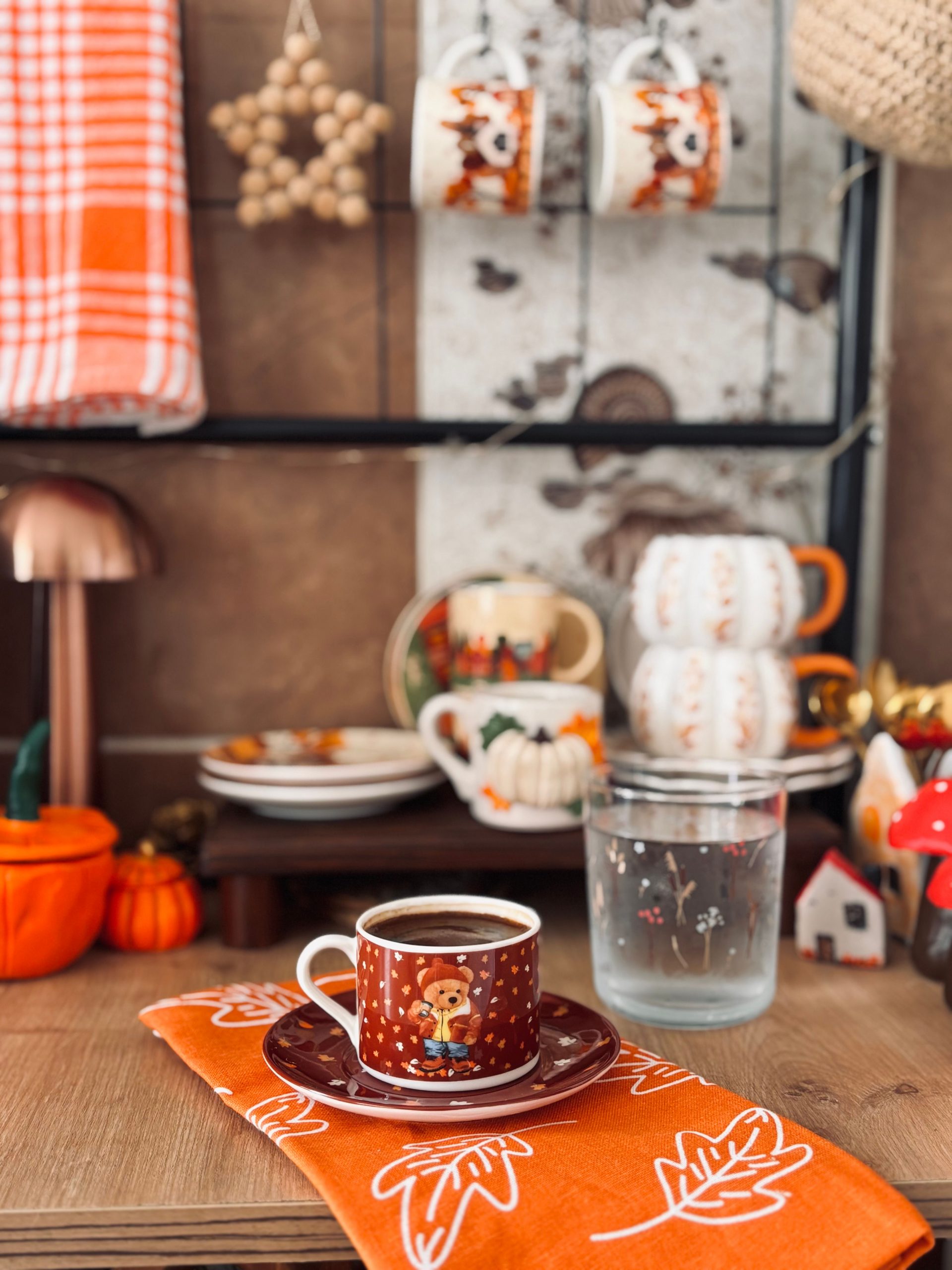 A warm and inviting autumn-themed kitchen decor featuring a coffee cup and pumpkin motifs.
