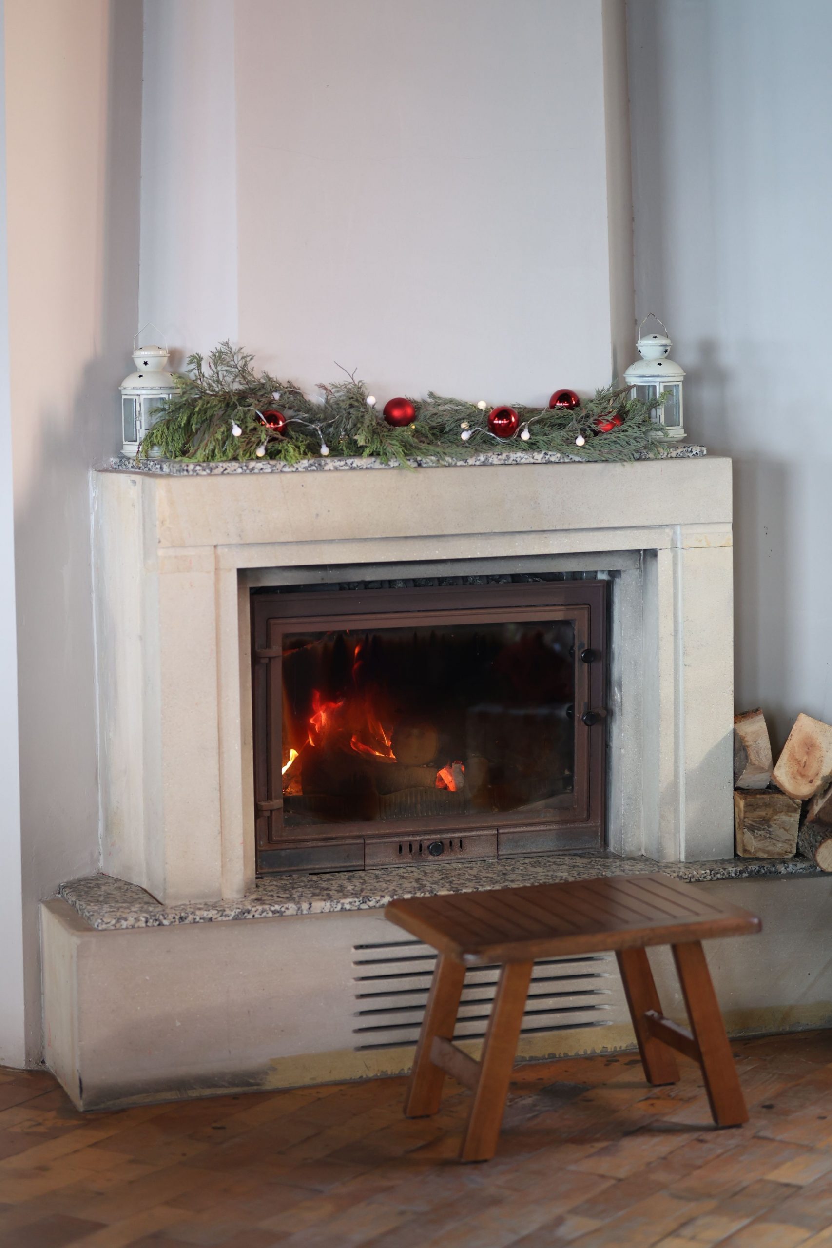 A warm, decorated fireplace with festive Christmas garlands and ornaments.