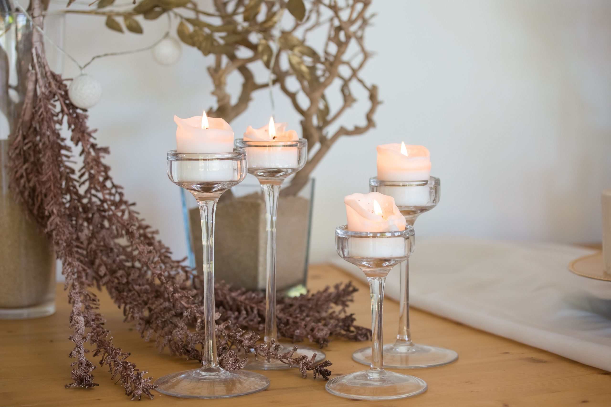 Aesthetic table arrangement featuring candlelit decor with dried plants and glass holders, perfect for a serene ambiance.