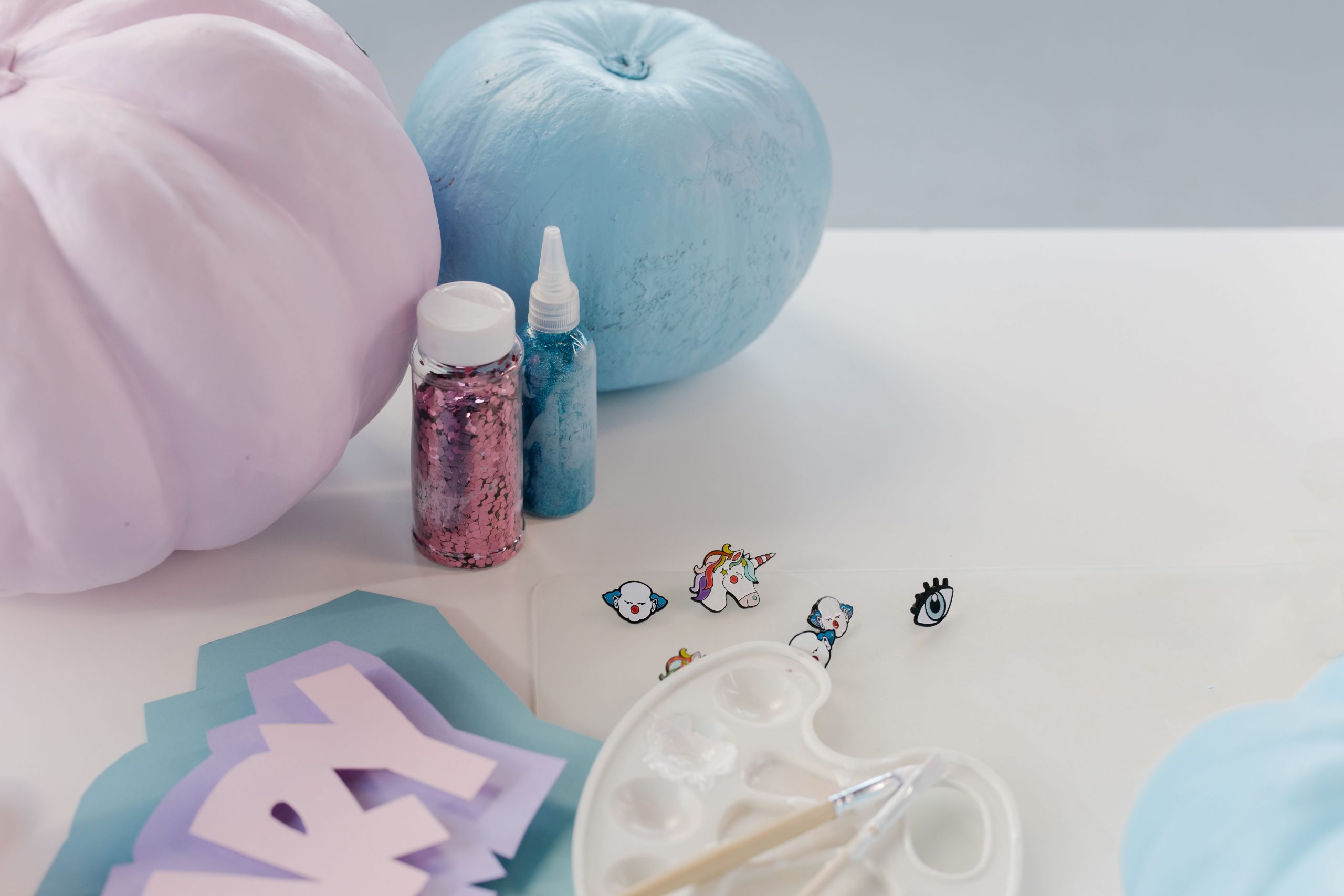 Artistic setup of pastel pumpkins and craft supplies, ideal for Halloween creativity.