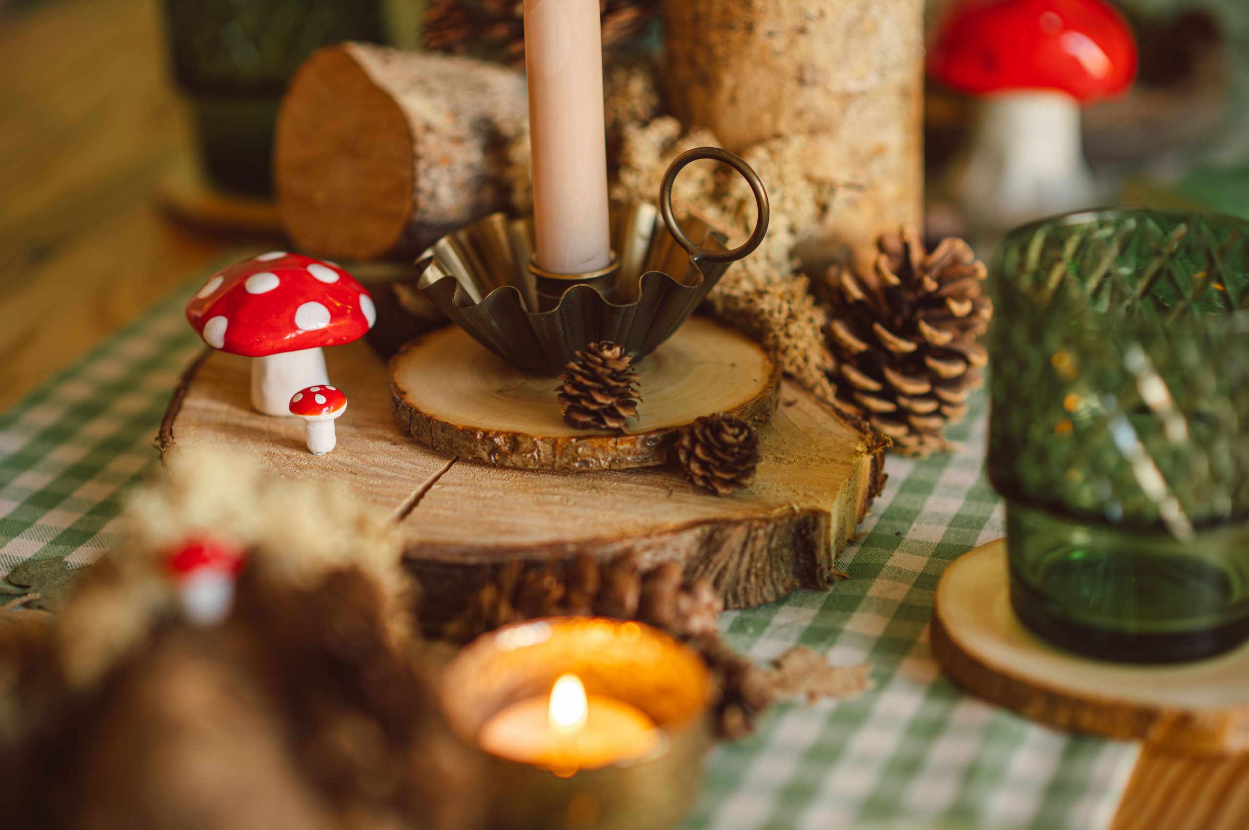 Charming woodland-themed table setting with pumpkins, pine cones, and candles perfect for autumn decor.