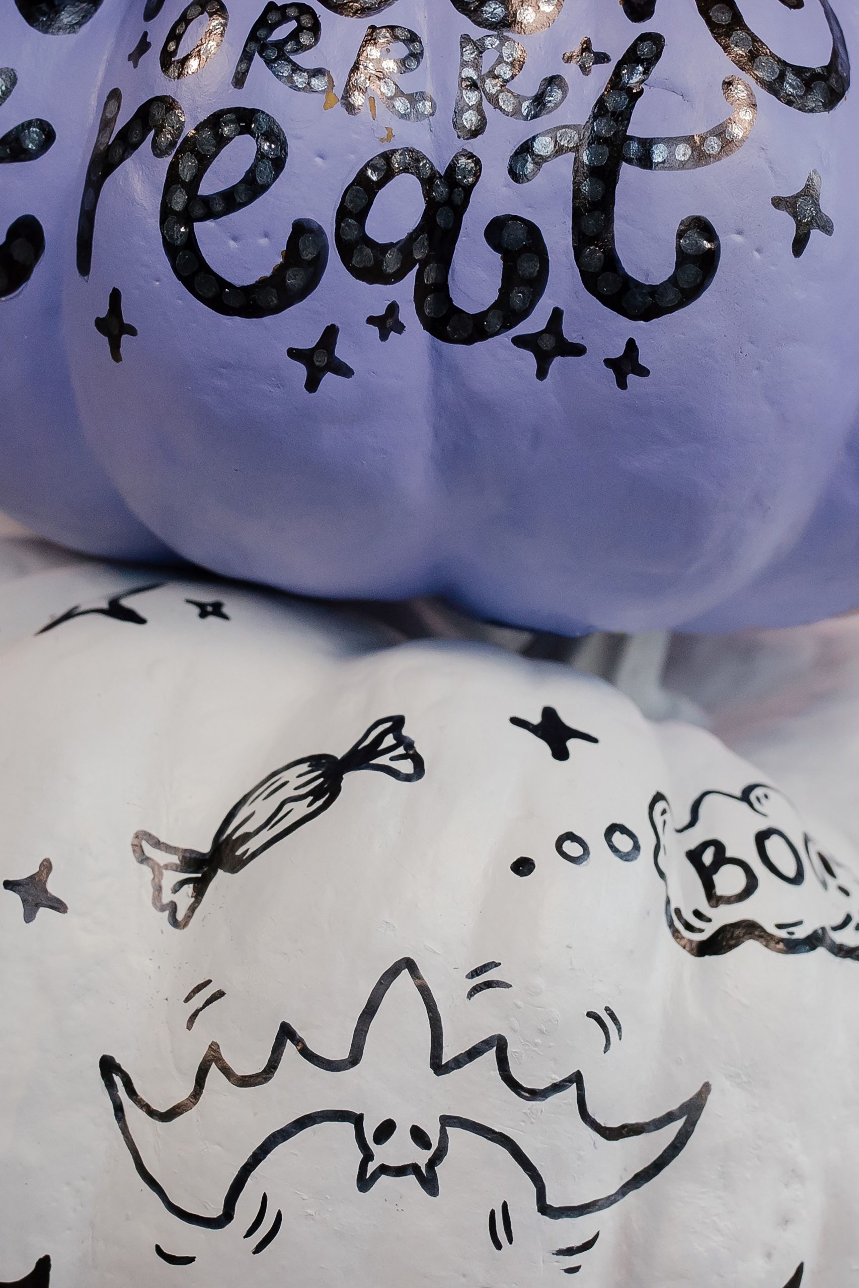 Close-up of creatively painted Halloween pumpkins with spooky designs for festive decoration.