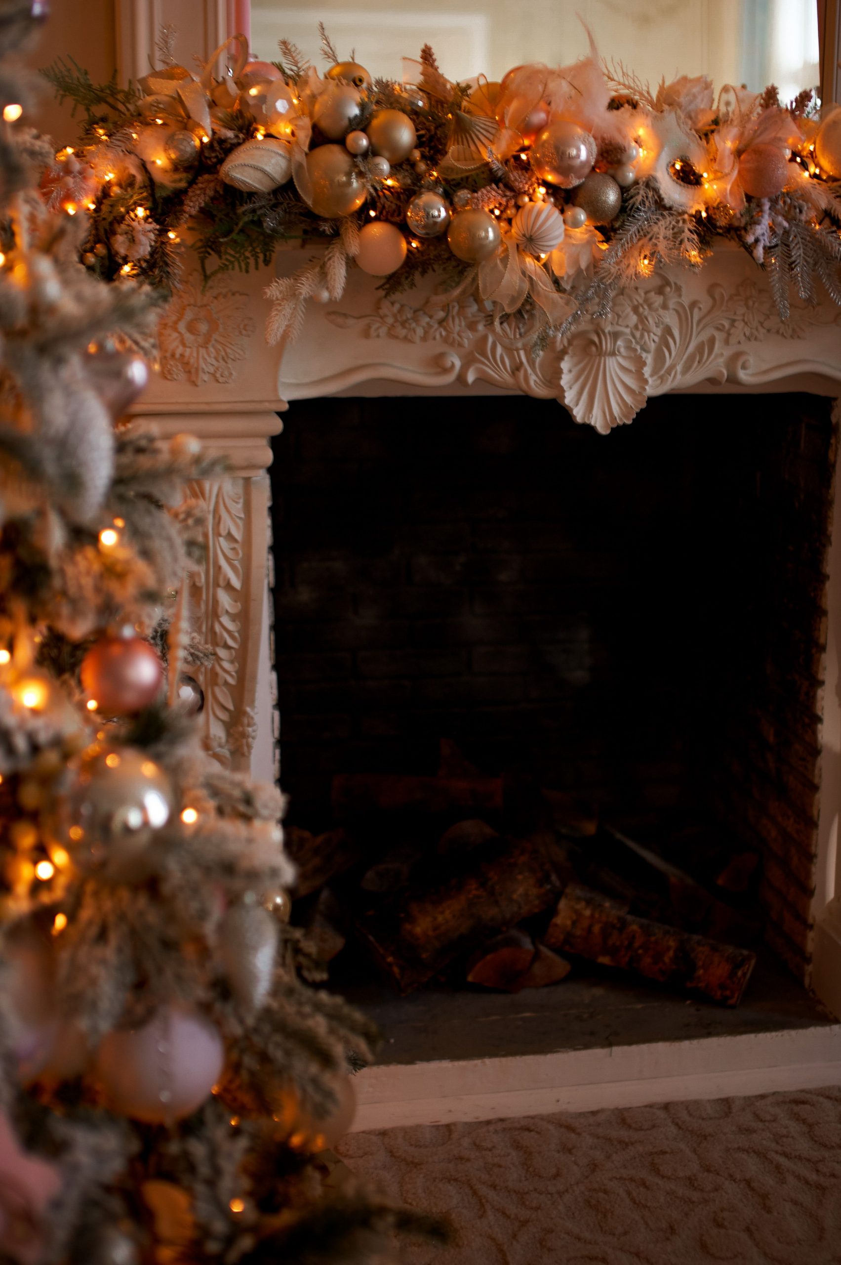 Cozy Christmas fireplace adorned with festive garland and ornaments, glowing warmly.