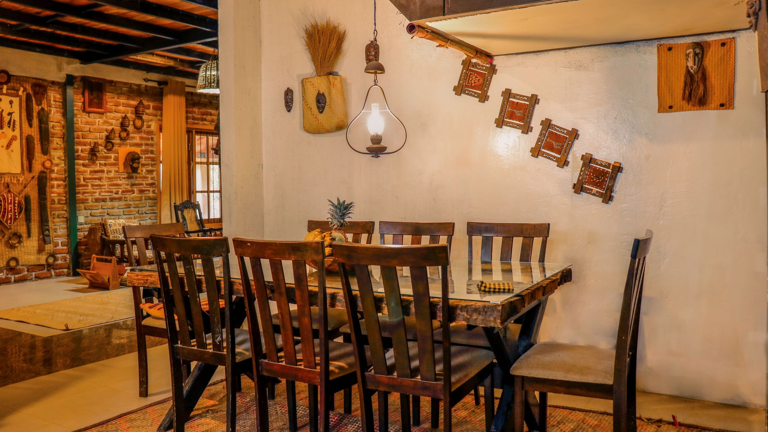 Cozy rustic dining room featuring wooden furniture, warm lighting and eclectic wall decor.