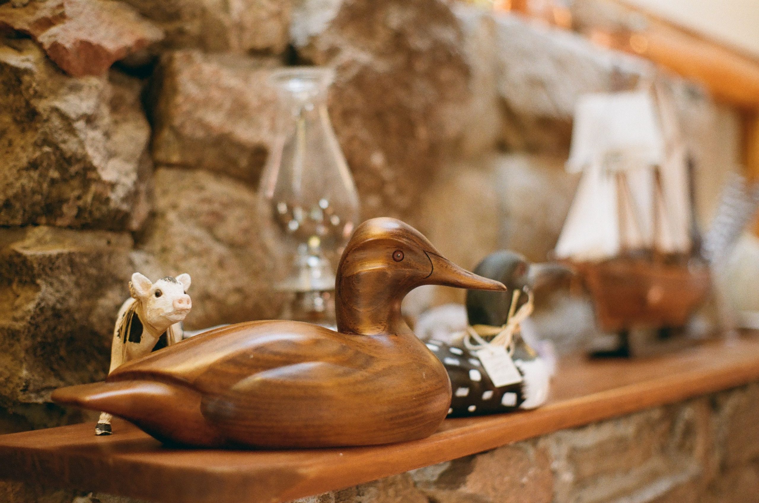 Cozy rustic shelf display with a wooden duck and decorative items.
