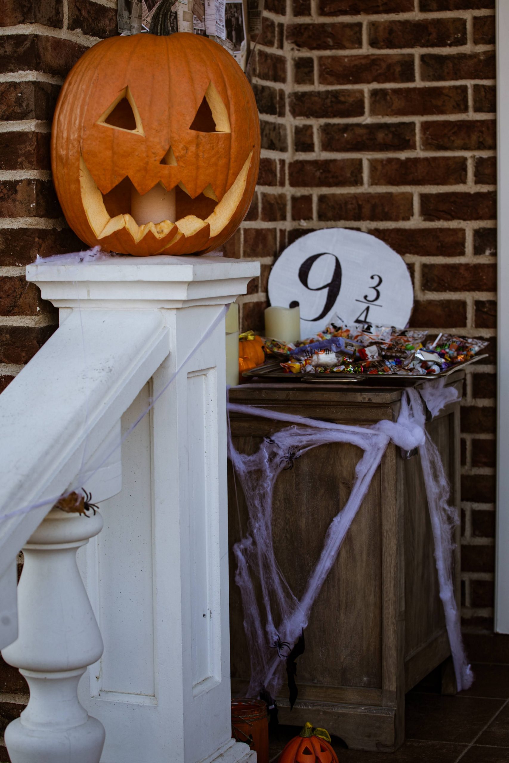 Creepy Halloween porch with carved pumpkin and spider web decorations.