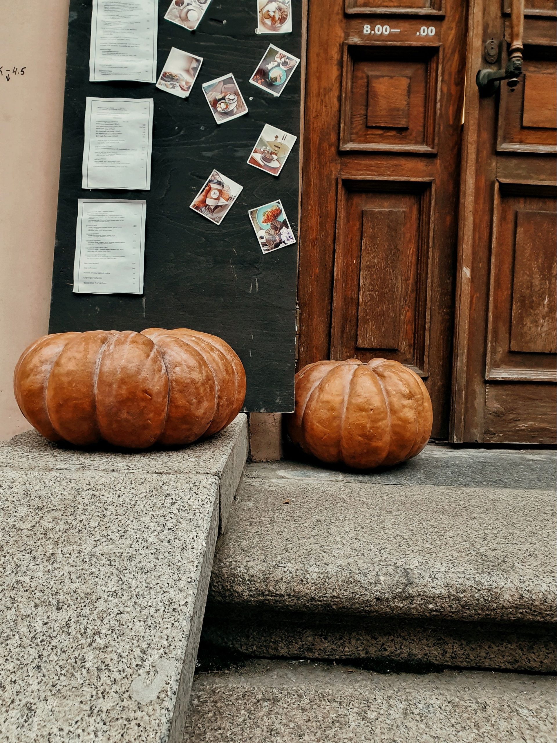Decorative pumpkins and notes adorn a rustic doorstep, capturing autumn vibes.