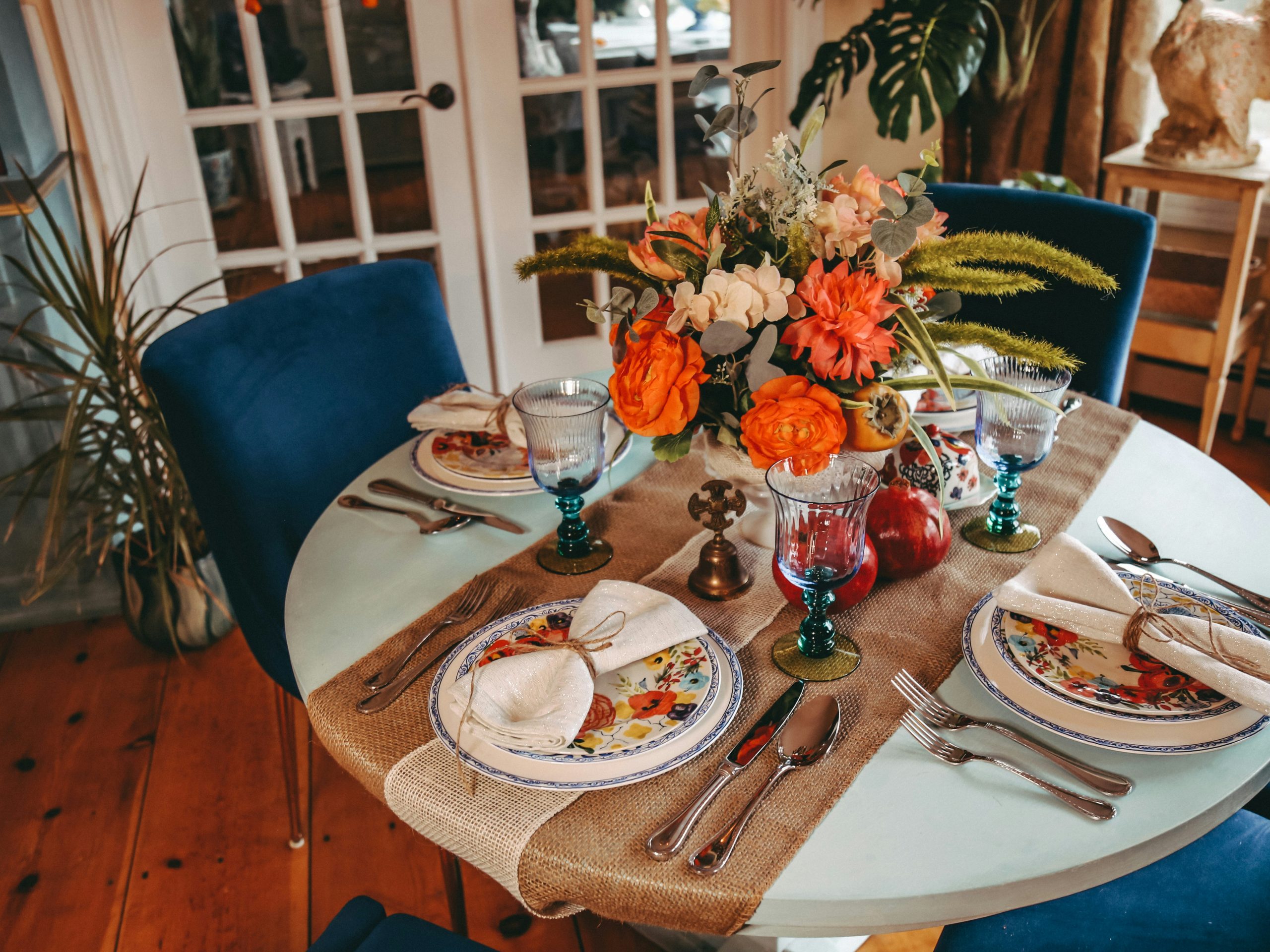 Dining room decorated for autumn / fall holidays. Thanksgiving or autumn harvest with warm tones and velvet chairs.