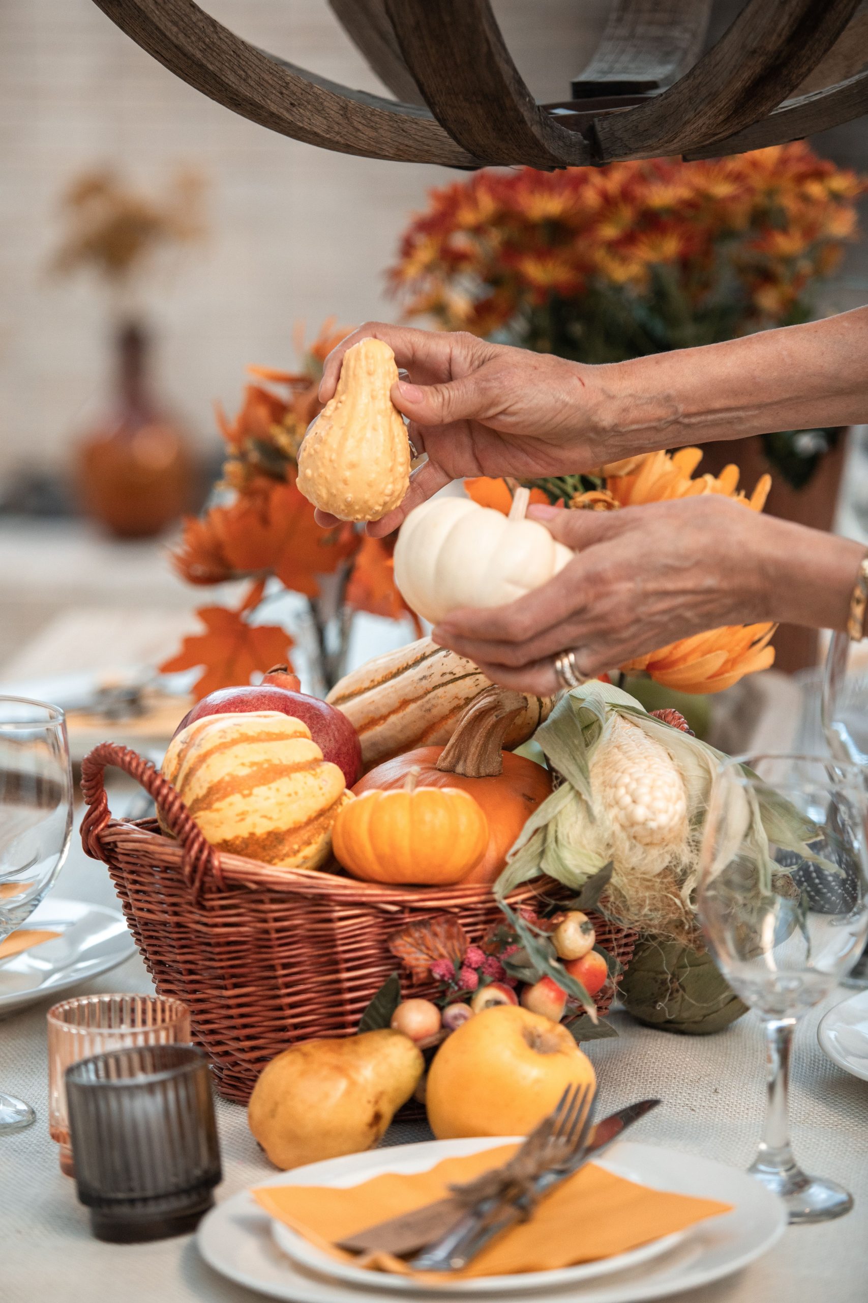 Festive autumn table featuring a basket of gourds and fall decor, perfect for Thanksgiving.