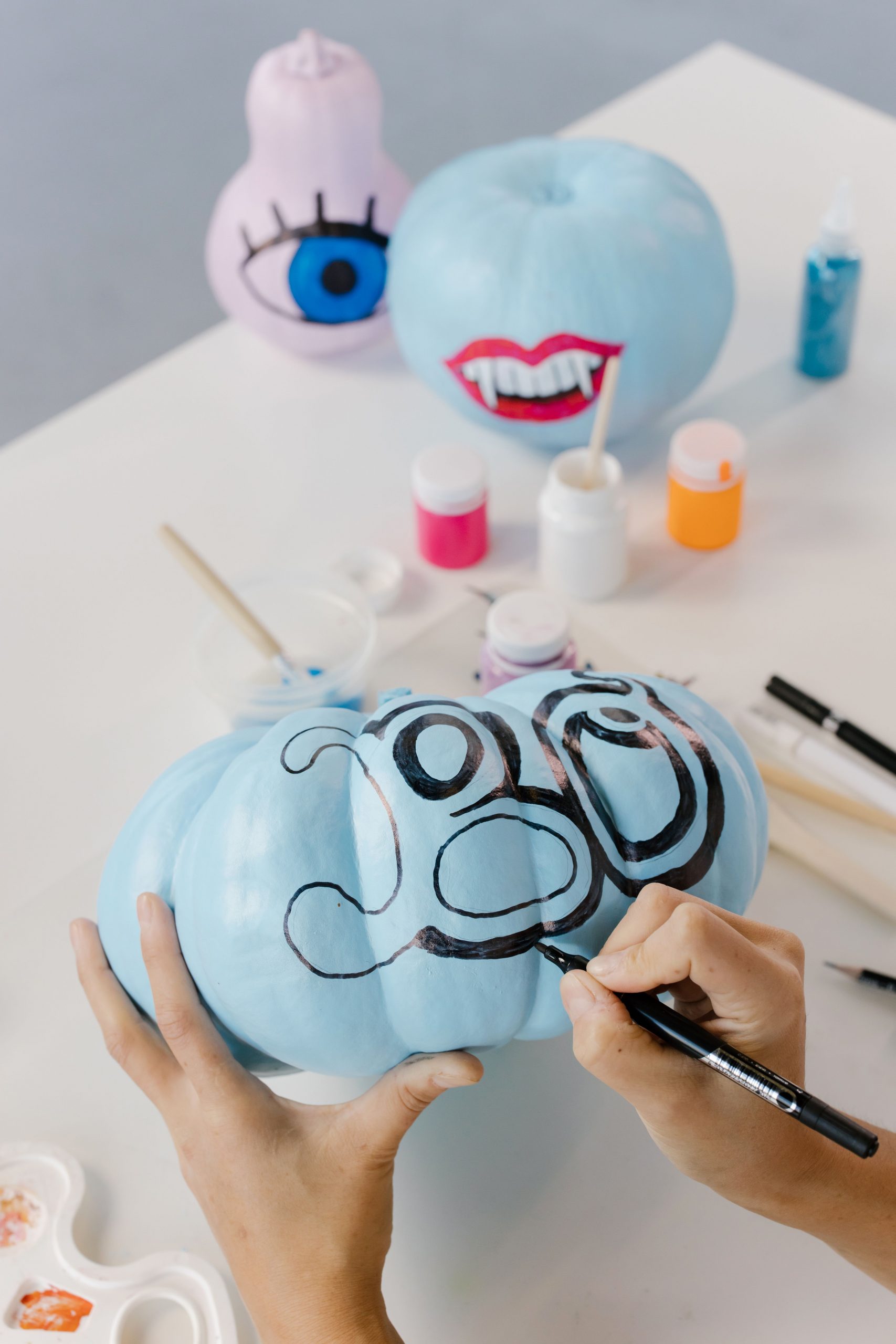 Hand-painted pumpkins with colorful designs for a festive Halloween look.