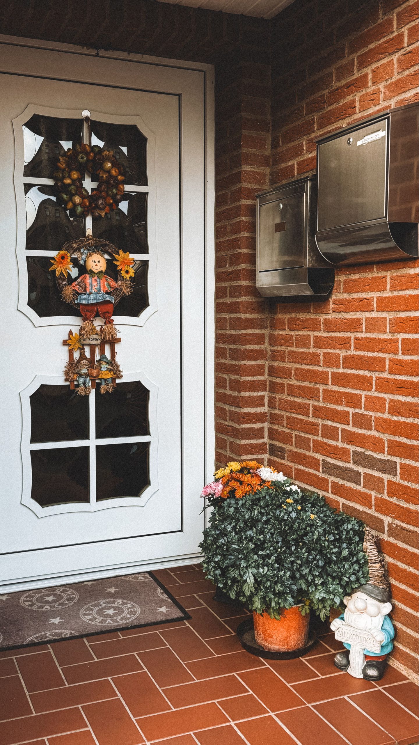 Inviting front door in Hannover adorned with autumn-themed decorations and vibrant flowers.