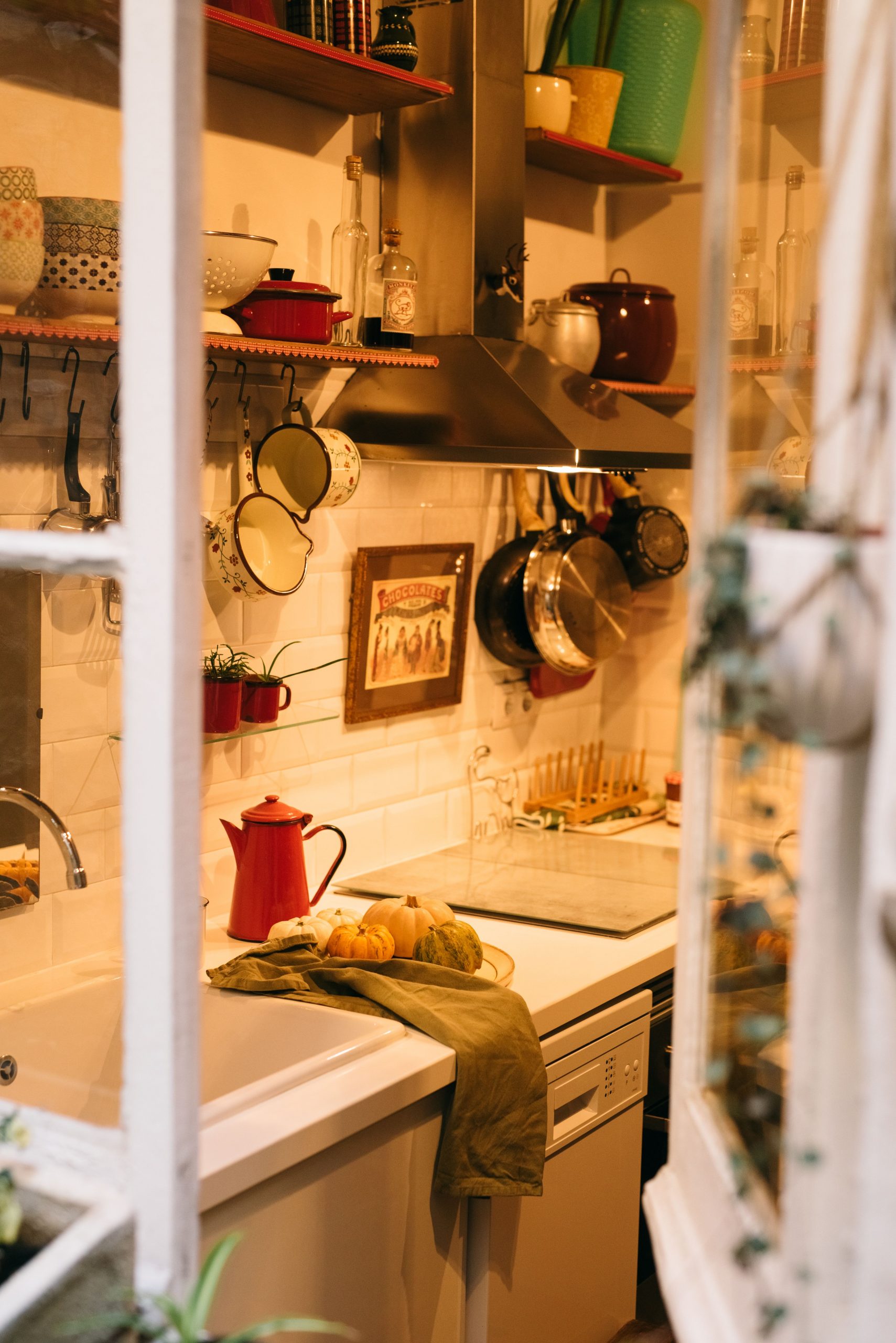 Inviting kitchen with rustic charm, featuring pots, pans, and autumn pumpkins.