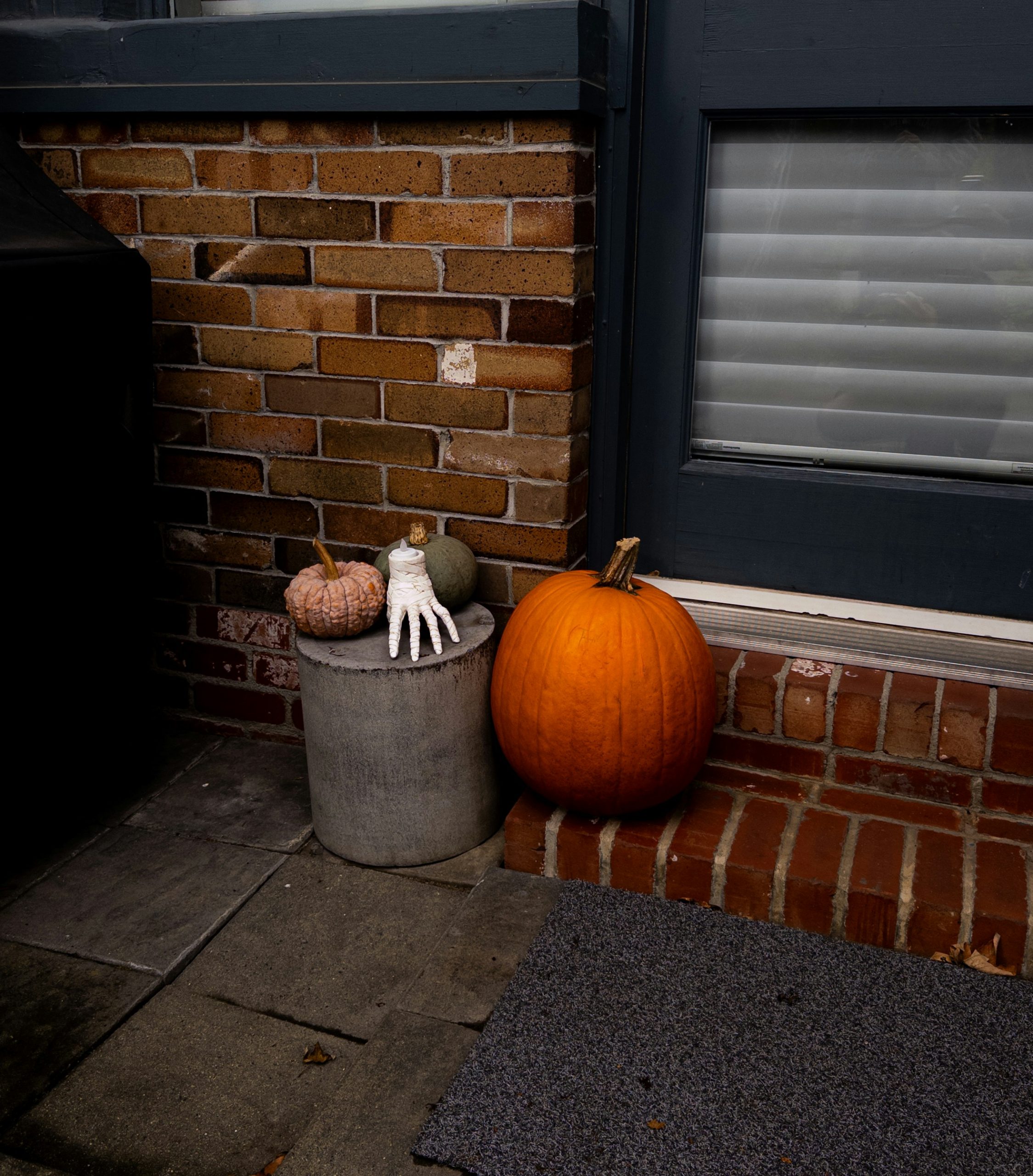 Pumpkins and garden glove by a brick wall