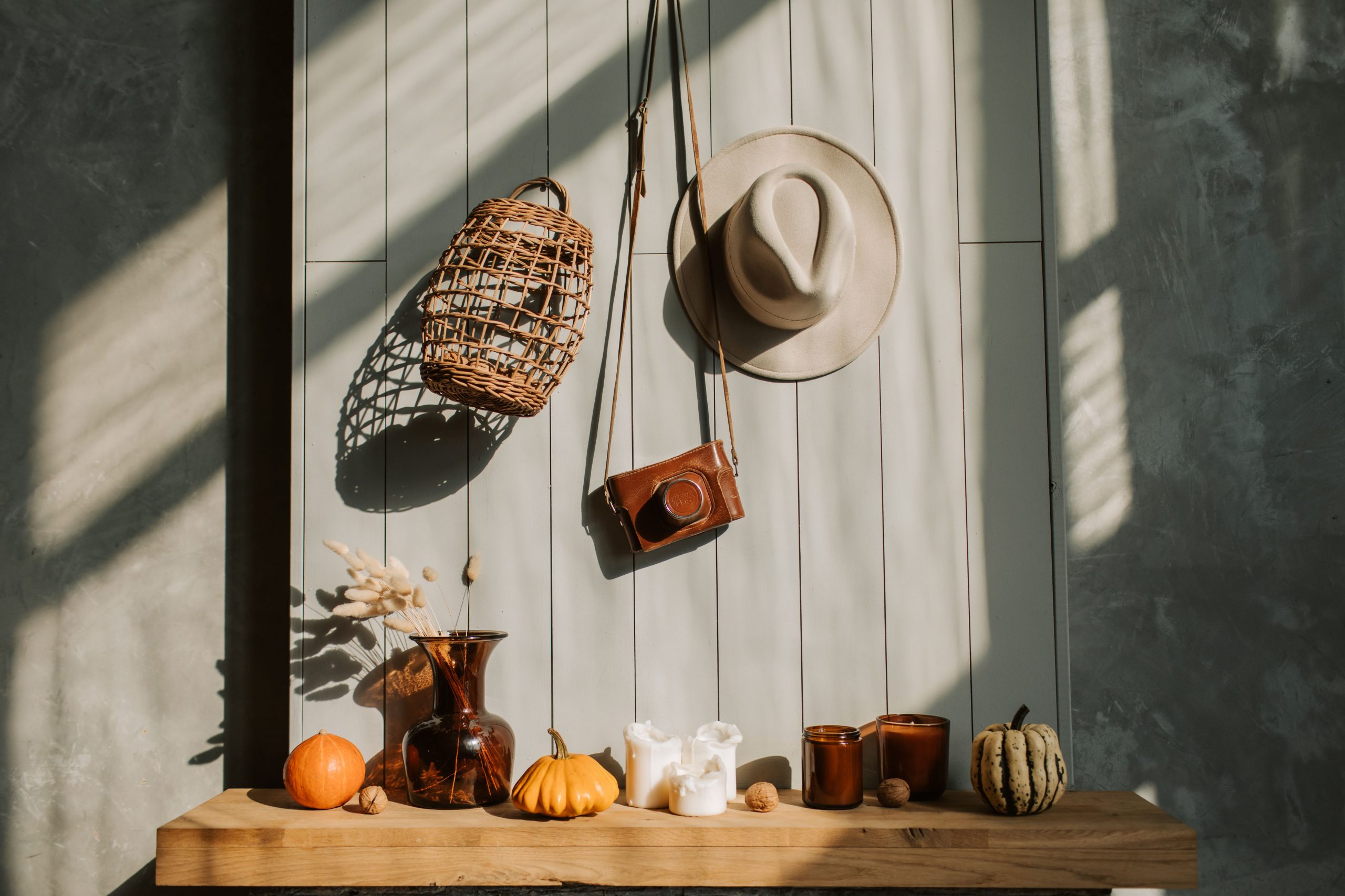 Sunlit composition with pumpkins, candles, and rustic decorations creates a cozy autumn ambiance.
