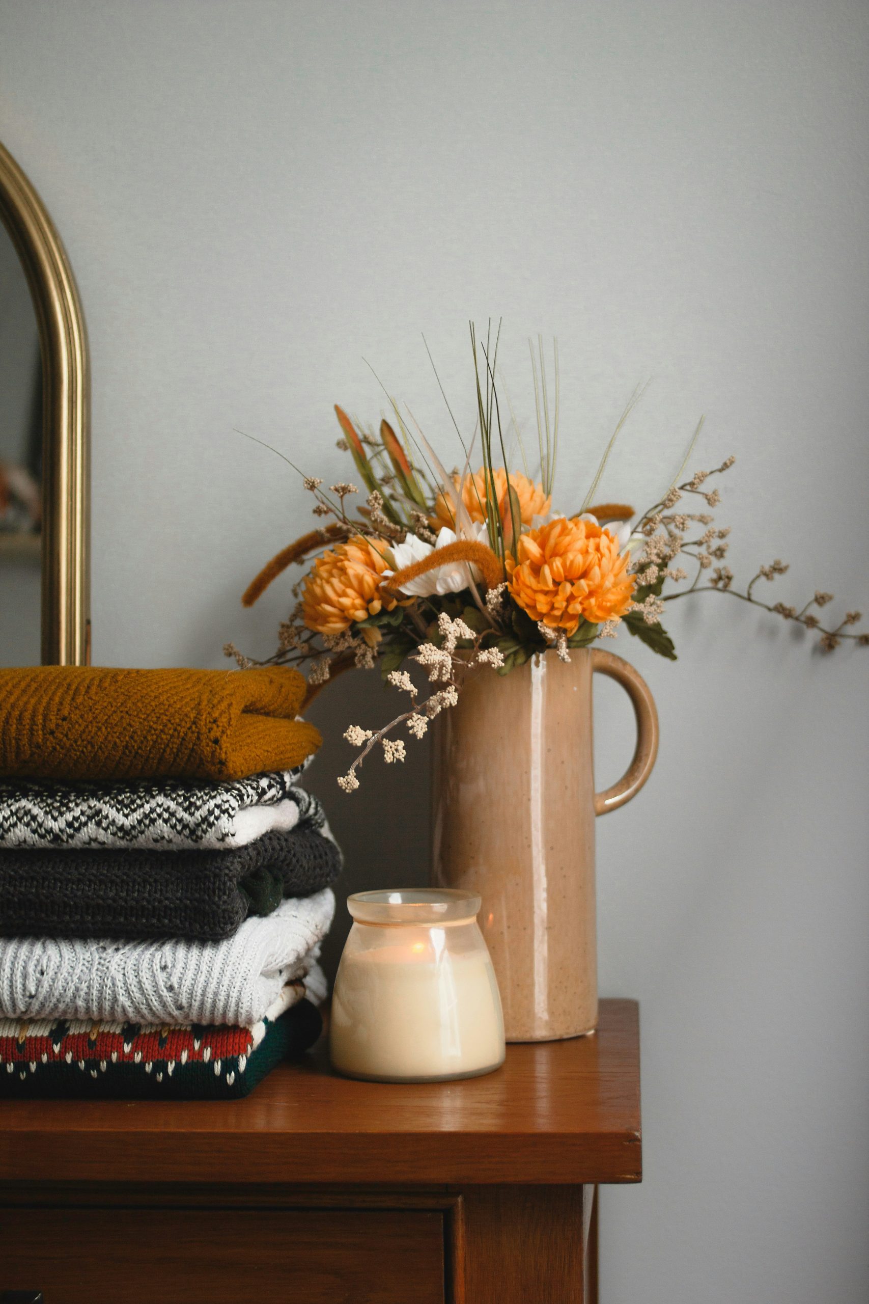 Thrifted sweater on a warm tone dresser.