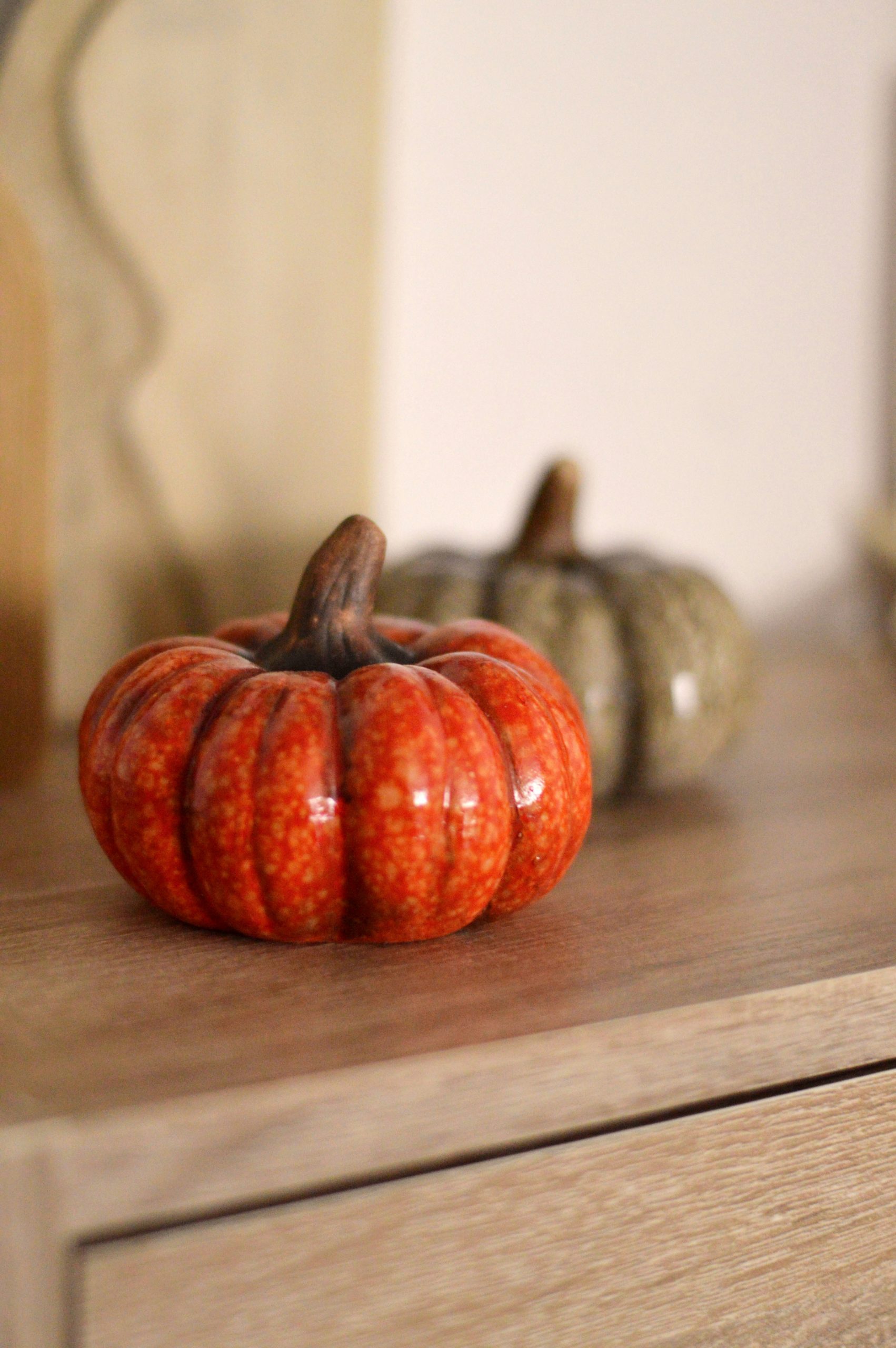 Two decorative pumpkins on a wooden surface.