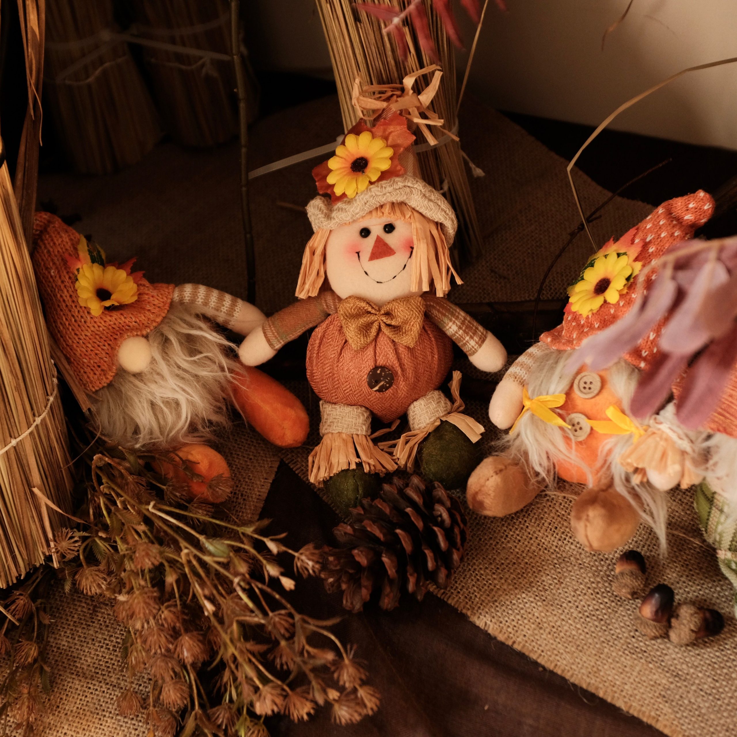 Vintage-style autumn decor featuring whimsical dolls and natural elements.