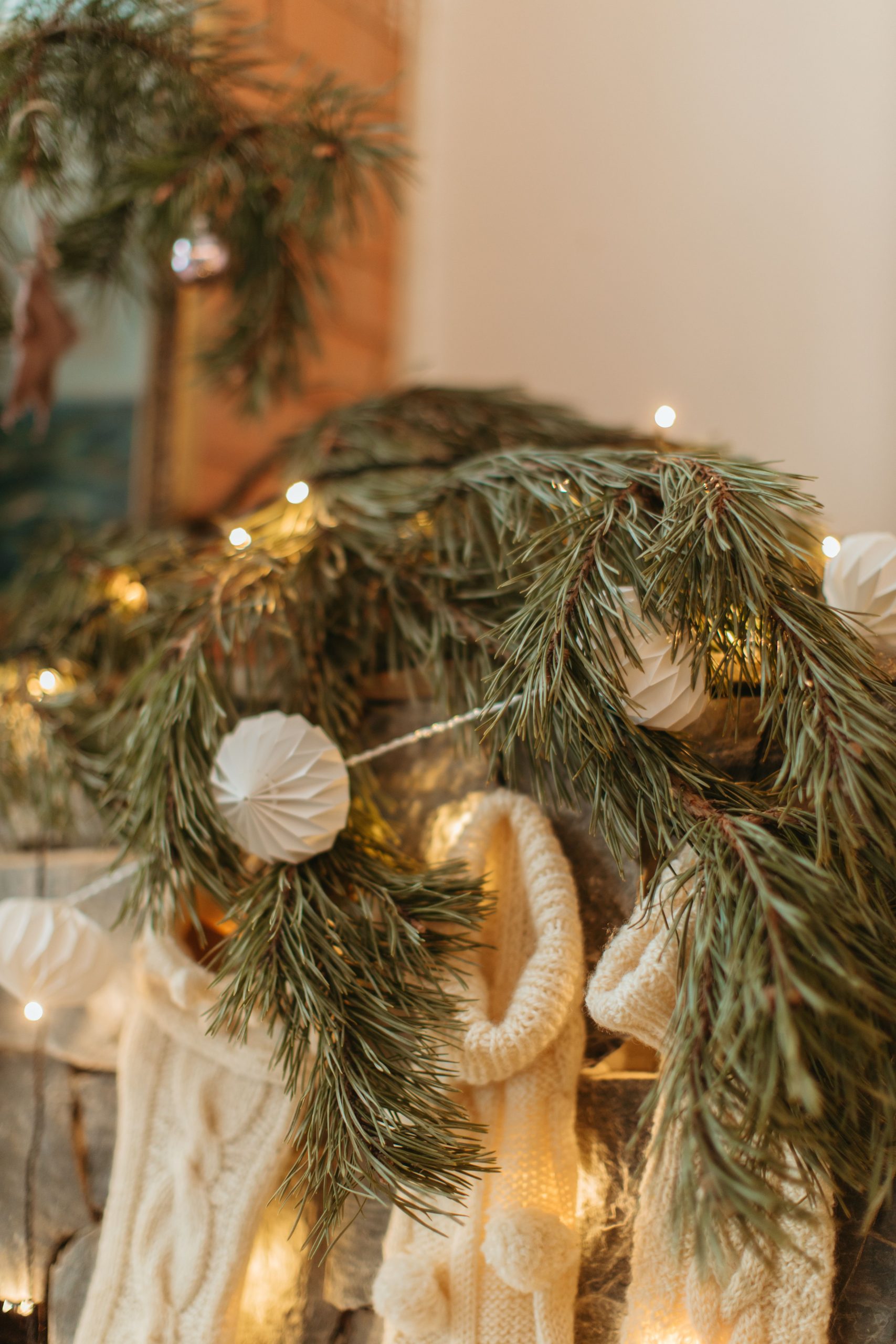 Warm and festive Christmas mantel decorated with pine branches, ornaments, and lights.