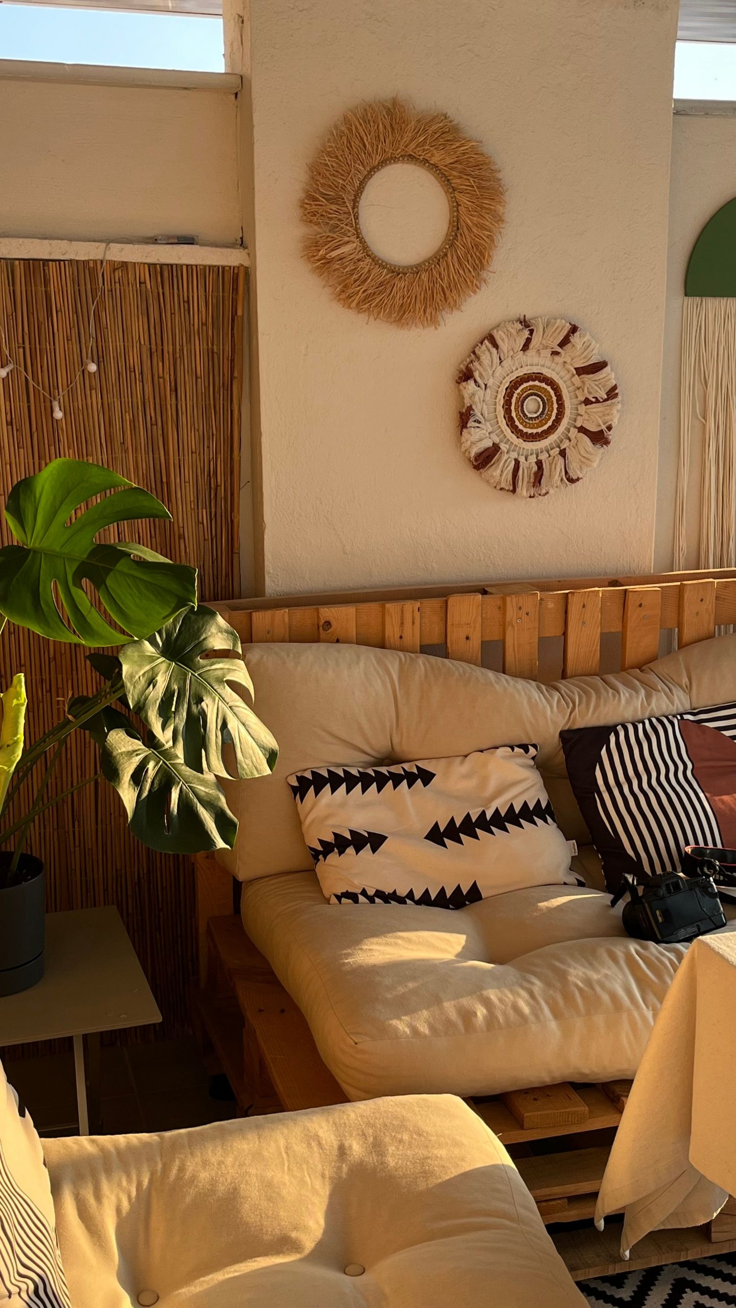 Warm and inviting sitting area featuring bohemian decor, plush couch, and indoor plant.