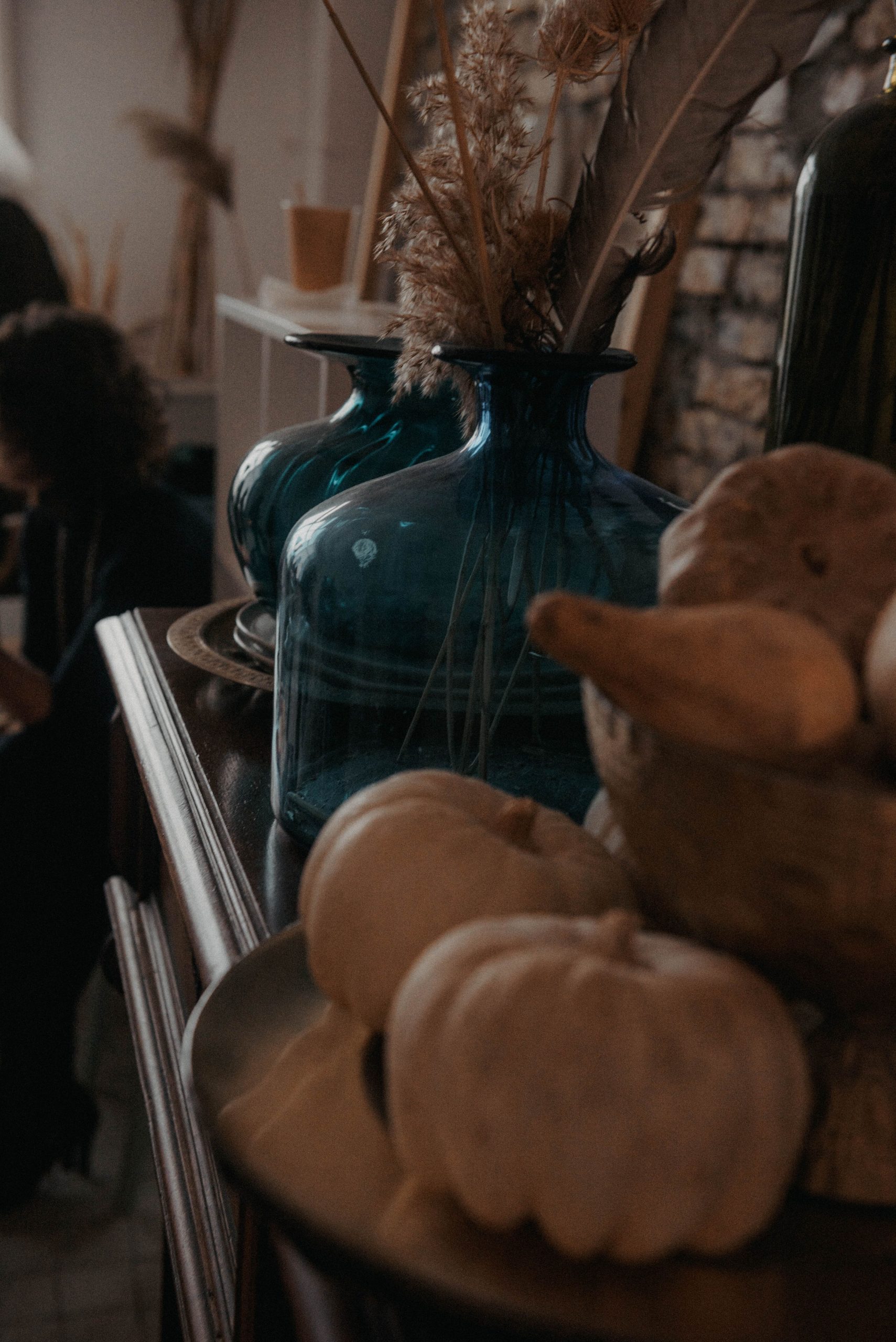 Warm autumn-themed still life with glass vases and gourds, perfect for cozy interior settings.