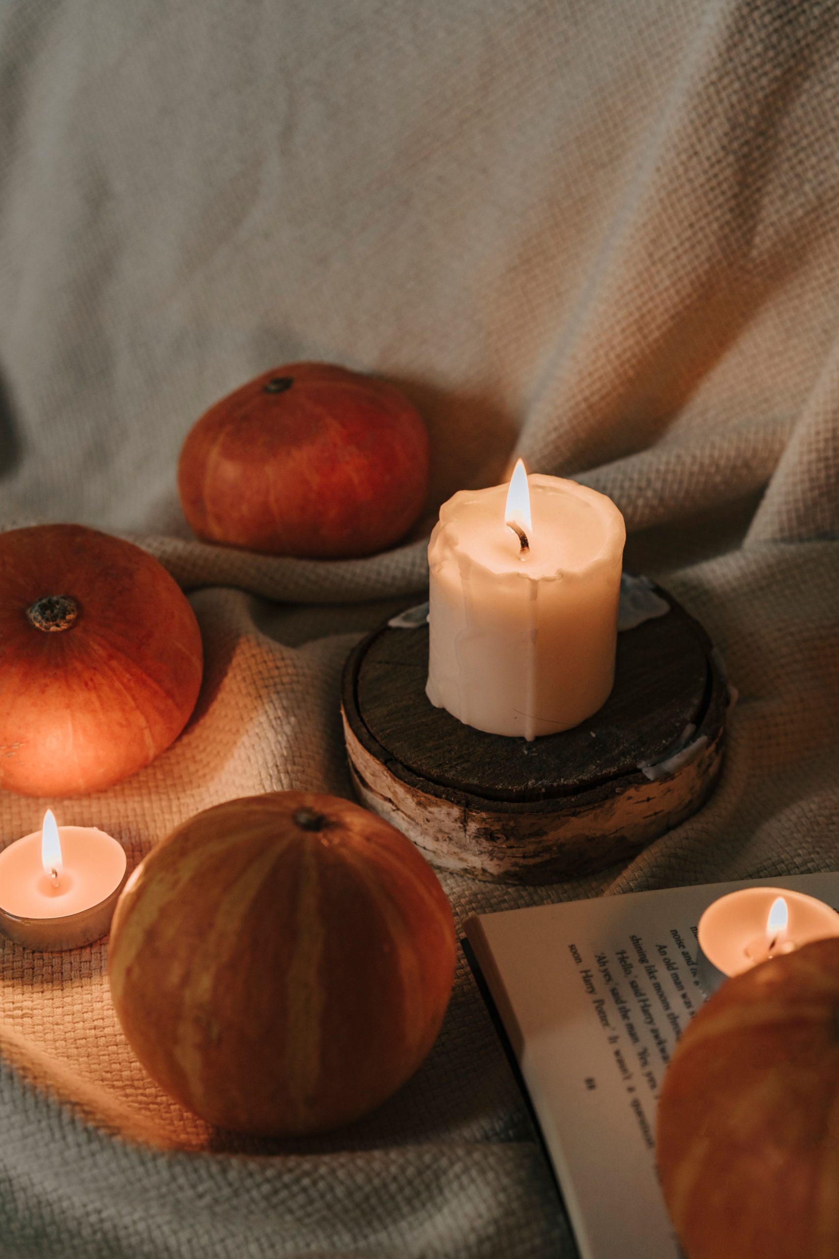 Warm autumnal scene with pumpkins, candles, and rustic elements, perfect for cozy fall vibes.