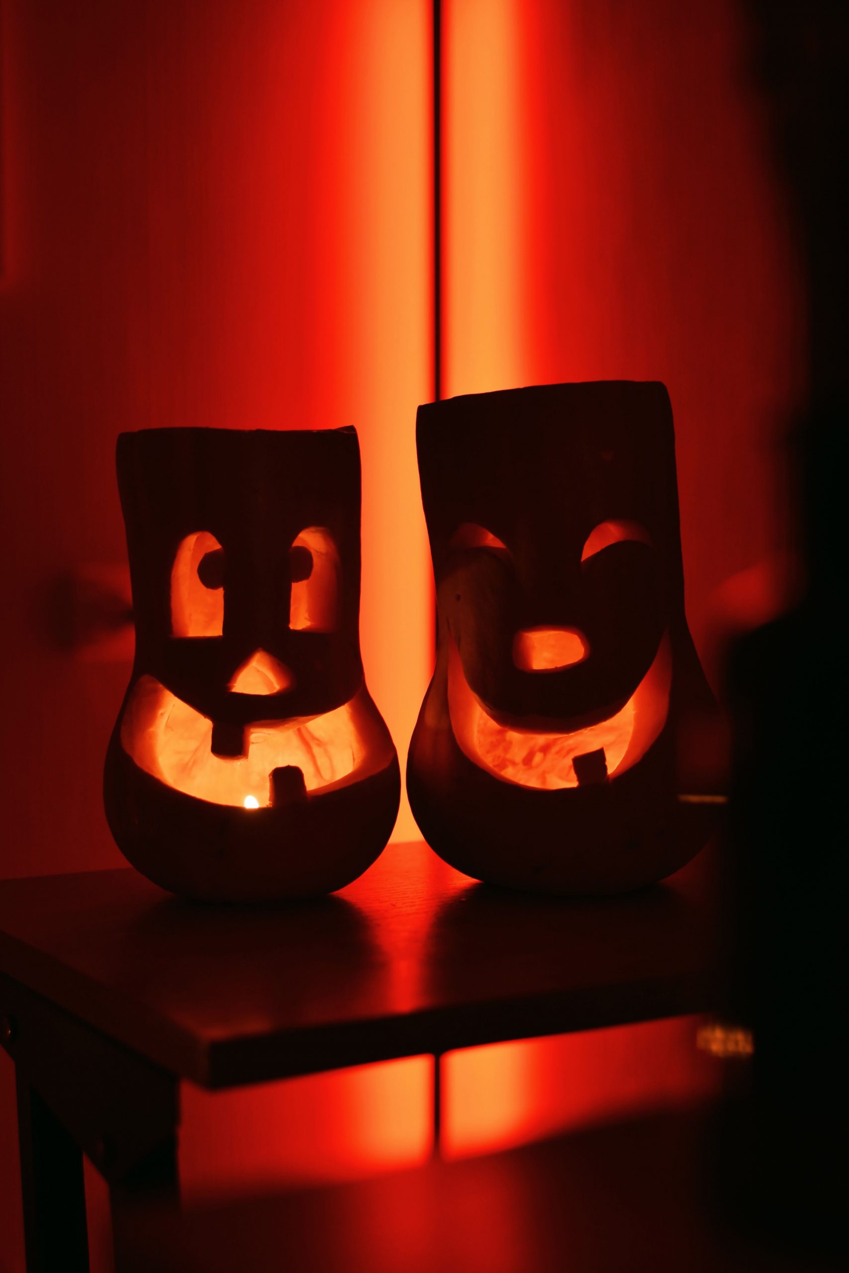 Warm candlelit shot of carved pumpkins creating a Halloween atmosphere.