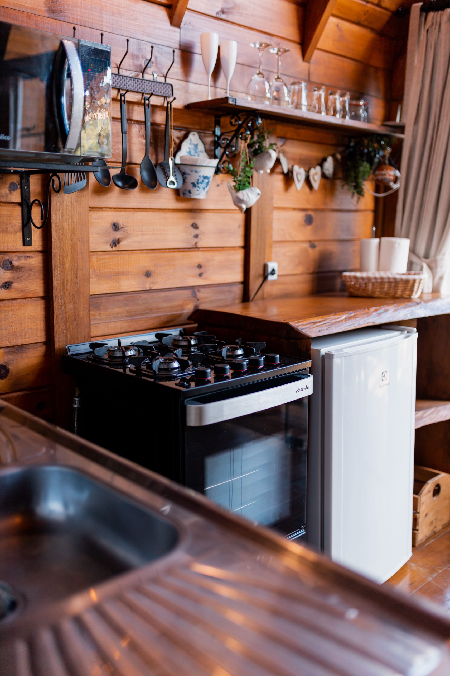 Warm rustic kitchen featuring wooden paneling and modern appliances, creating a cozy atmosphere.