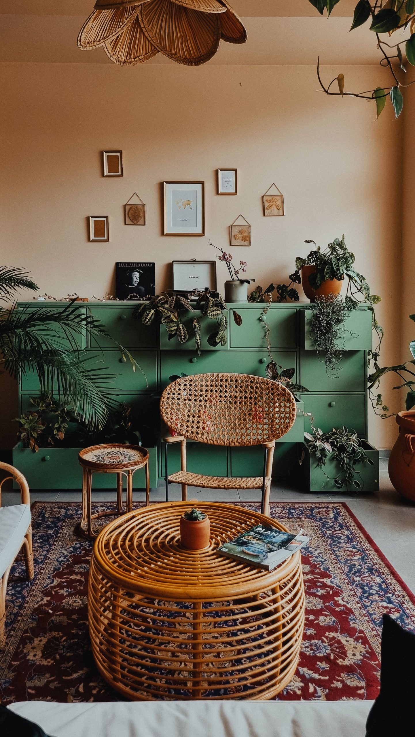 A bohemian-style living room with green accents and wicker furniture creating a cozy ambiance.