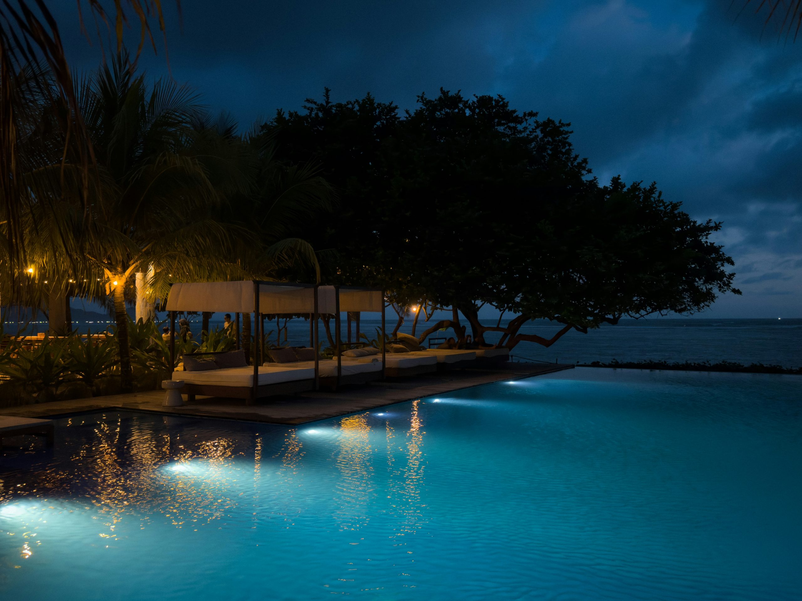 Illuminated swimming pool by the ocean at night