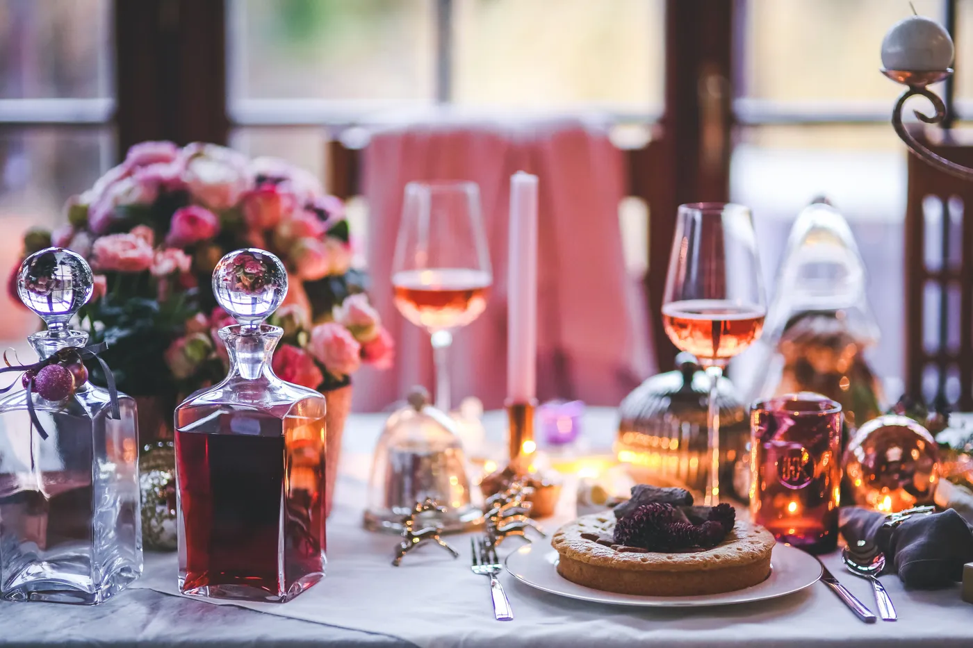 A beautifully set table with wine, flowers, and festive decorations, perfect for holiday celebrations.